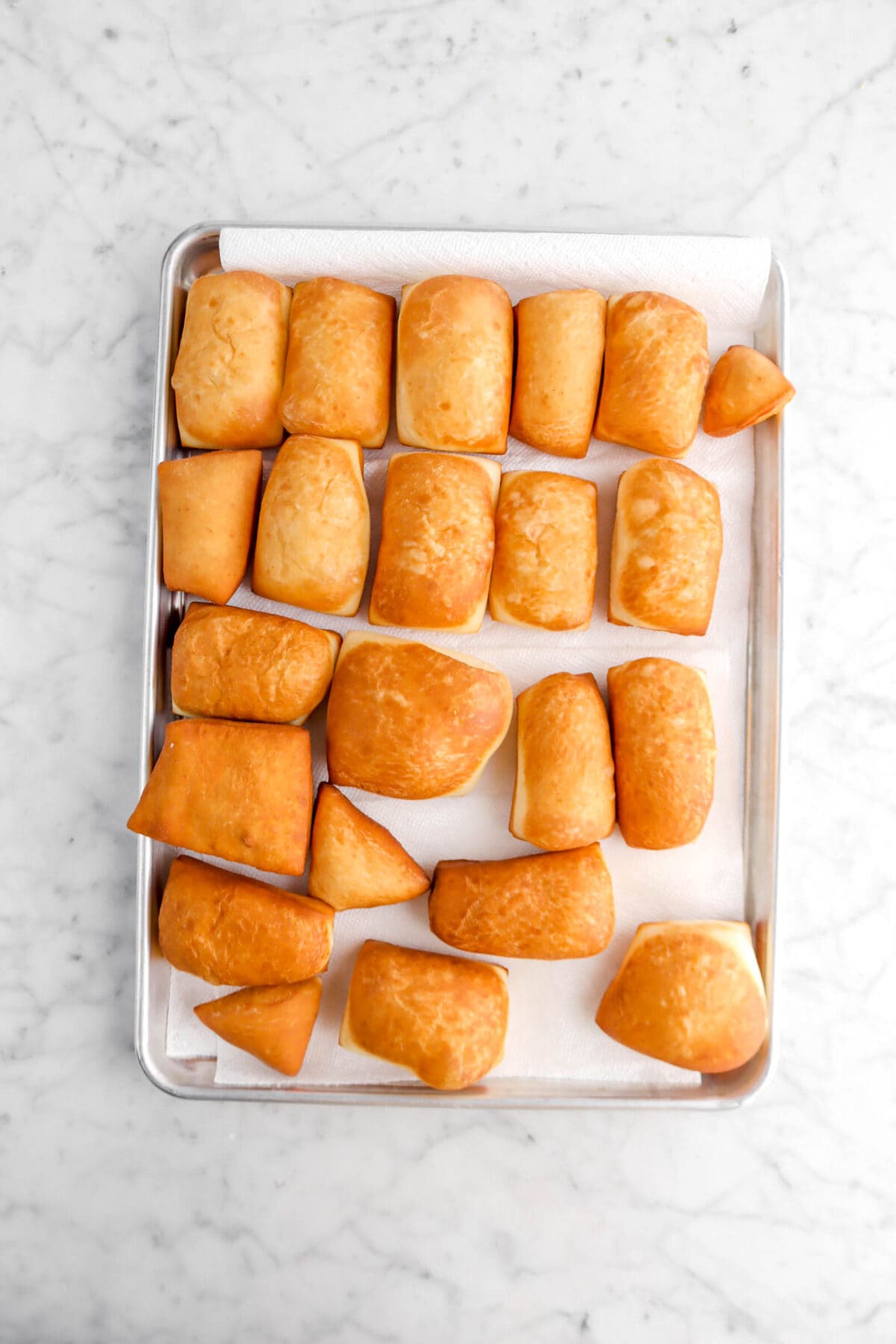 fried beignets on lined sheet pan