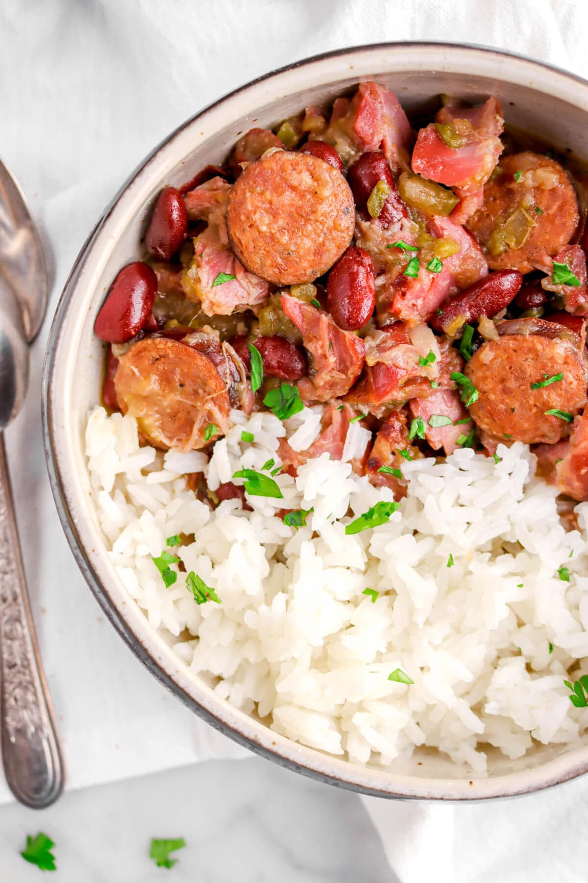 close up of red beans and rice in bowl with chopped parsley on top