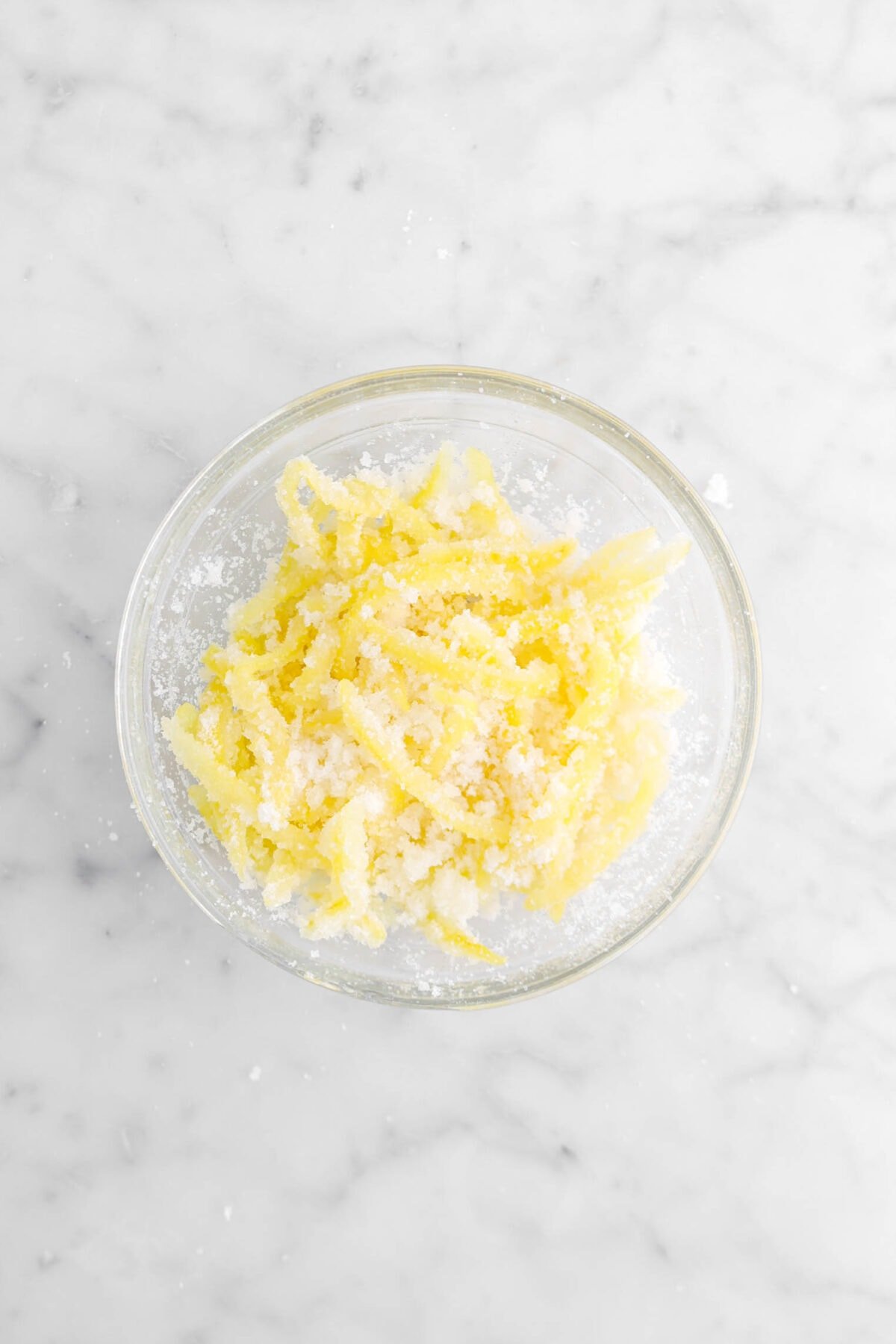 lemon peel coated in granulated sugar in glass bowl