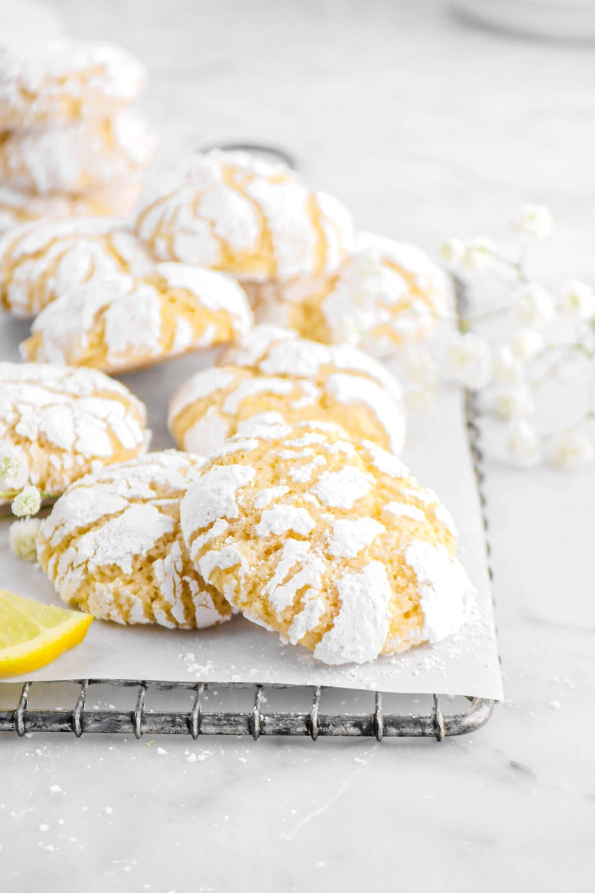 lemon crinkle cookies on small wire serving tray with parchment paper and flowers