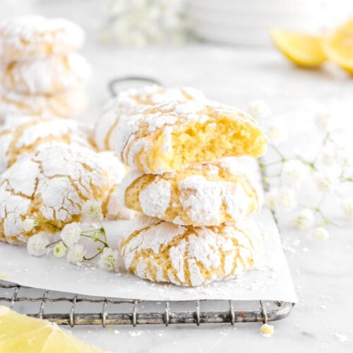 stacked crinkle cookies with lemon slices and flowers around