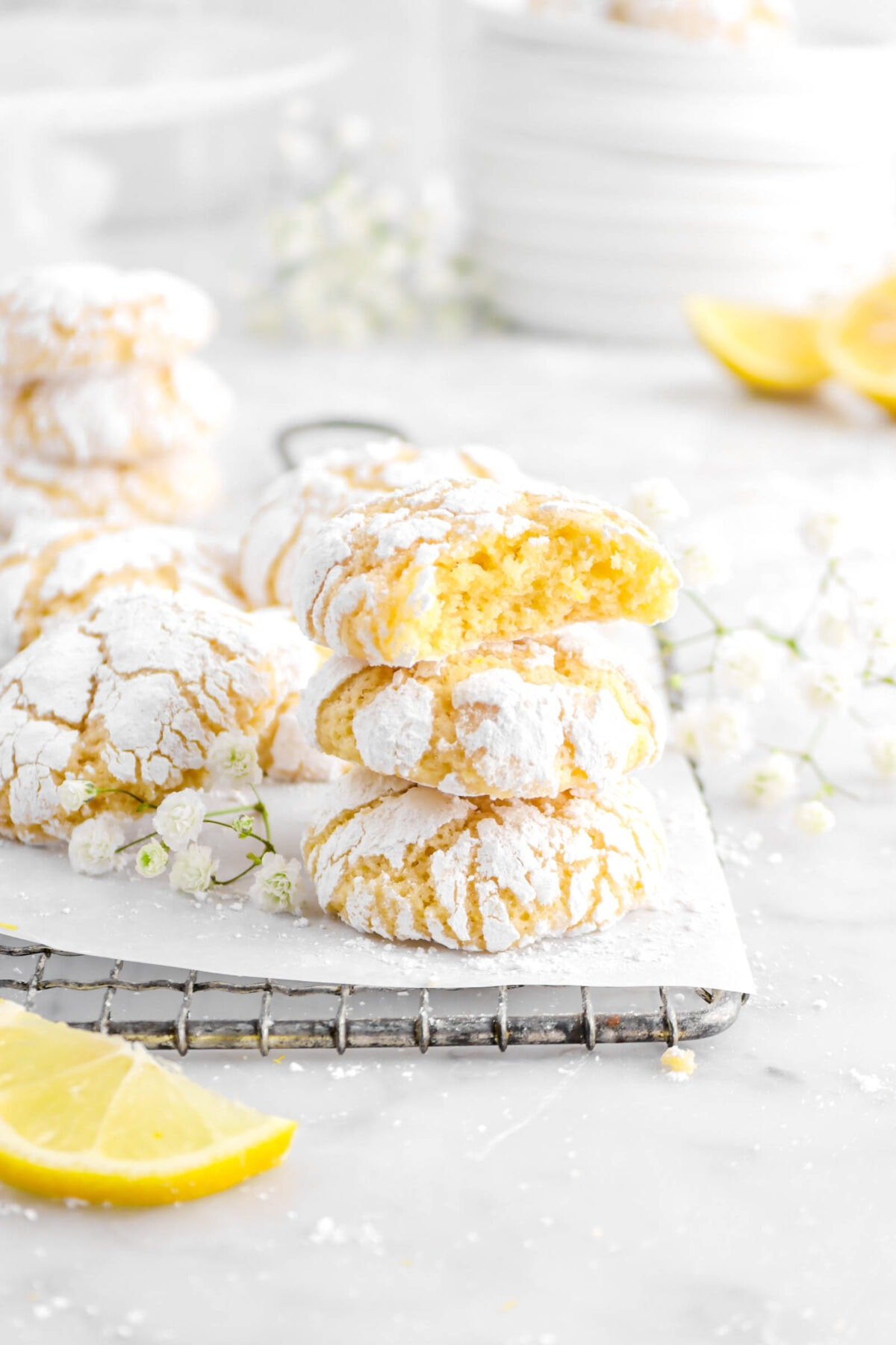 stacked crinkle cookies with lemon slices and flowers around