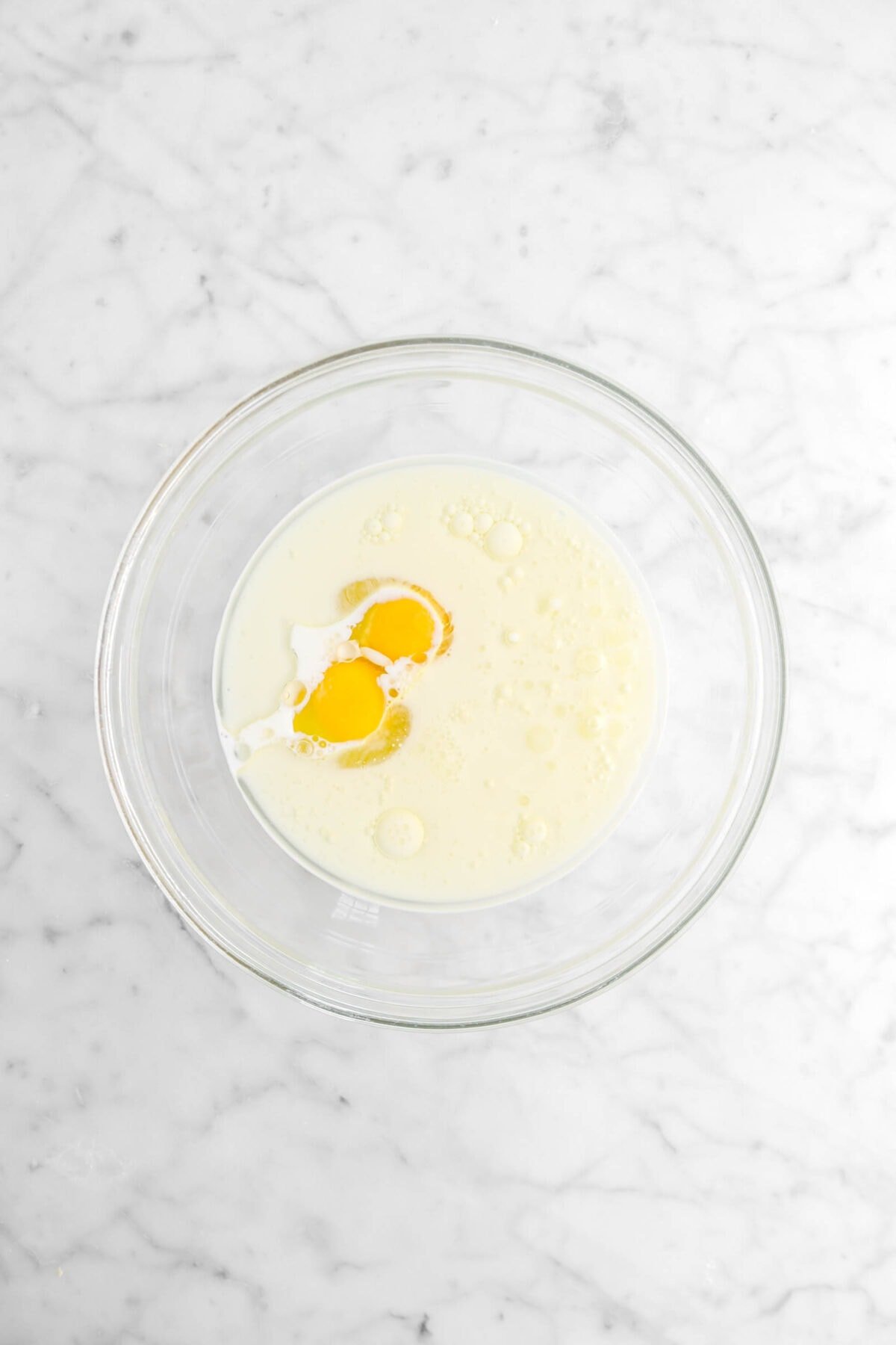 milk, eggs, and oil in glass bowl