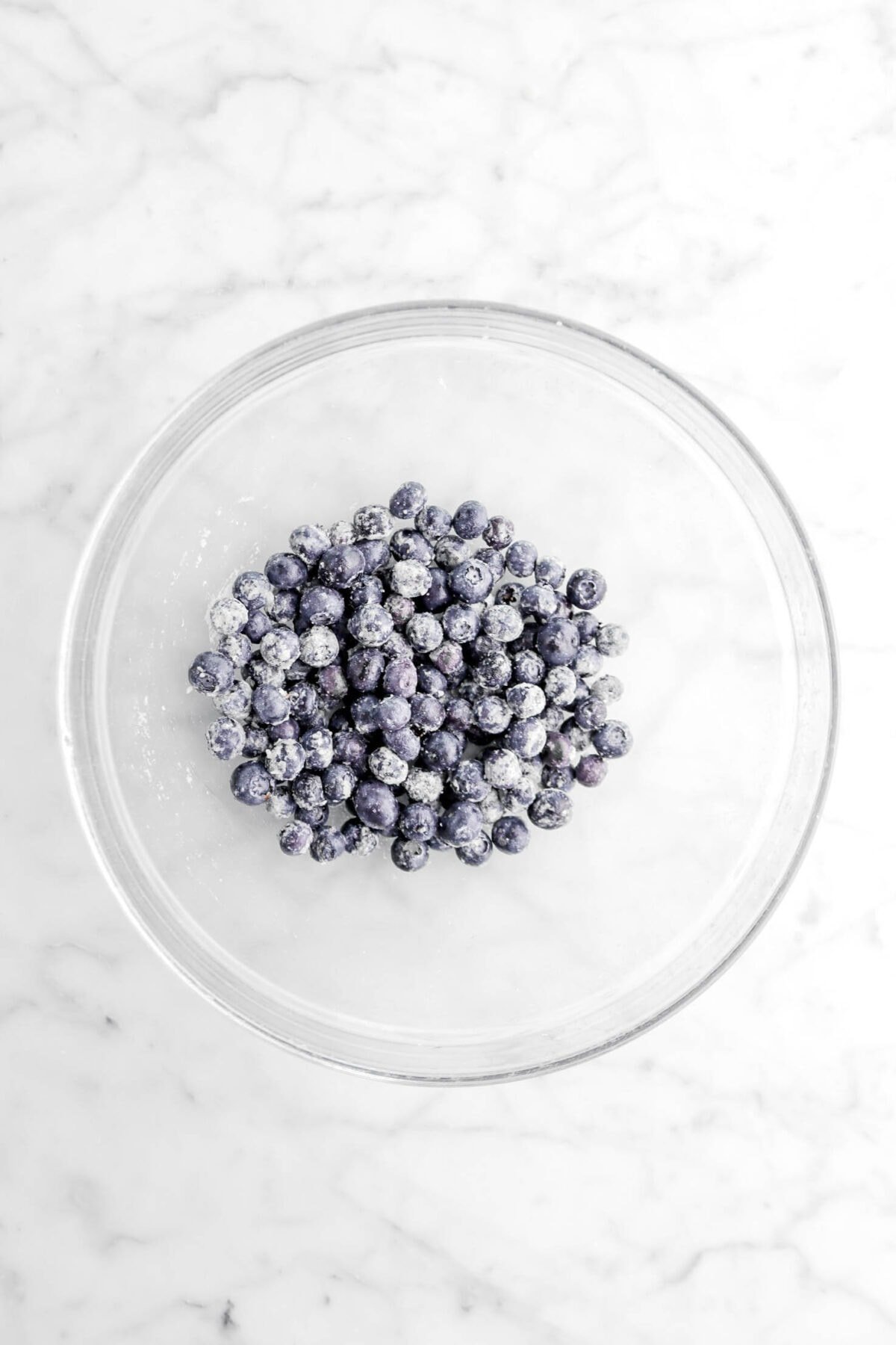 blueberries coated in flour in glass bowl