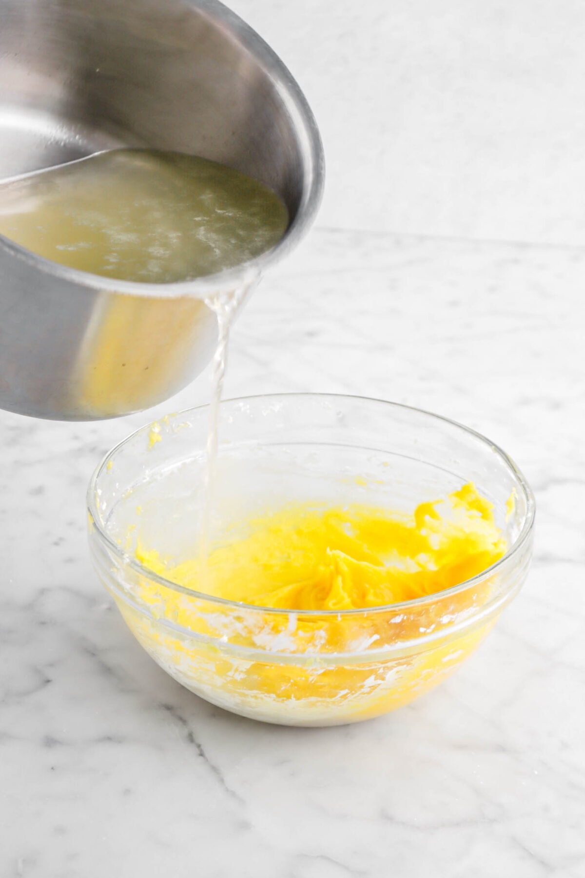 lemon mixture being poured into egg yolk mixture