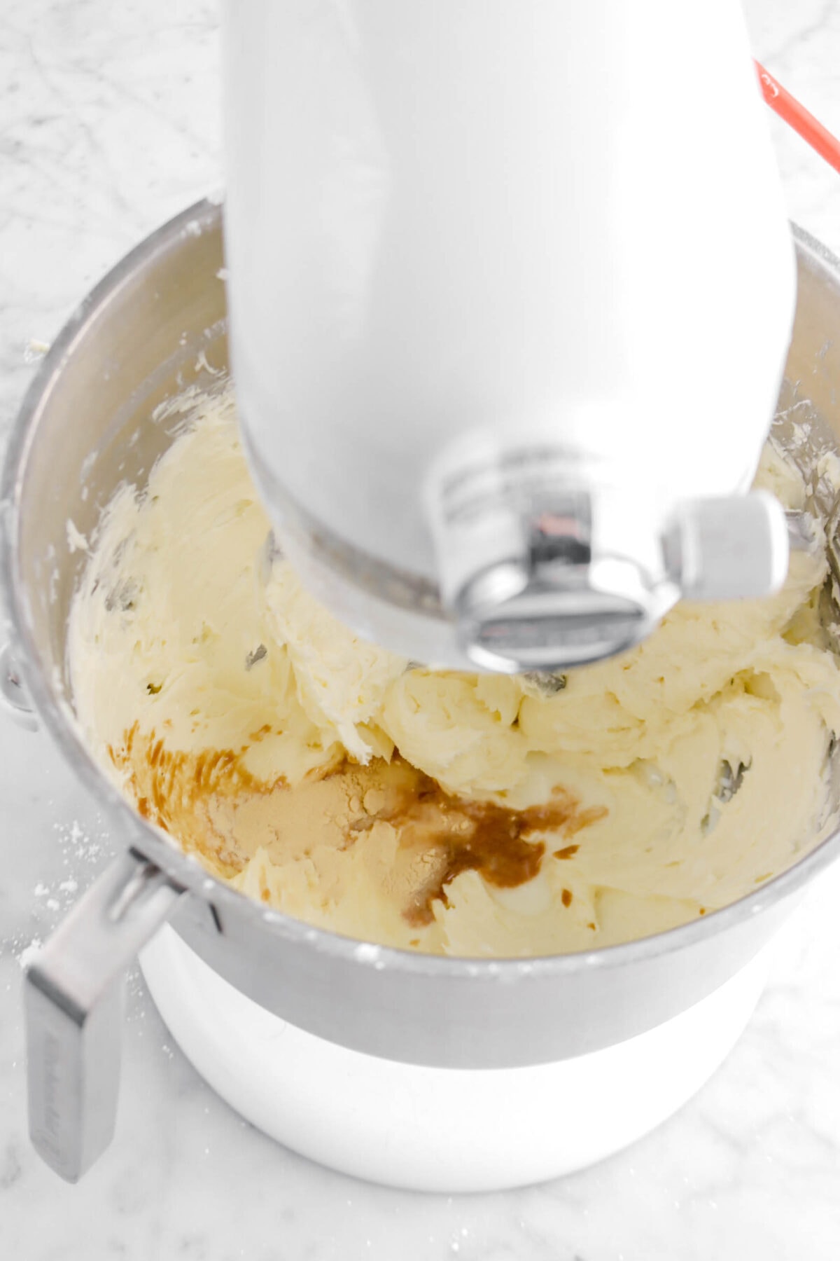 vanilla, heavy cream, and malt powder added to butter and powdered sugar mixture