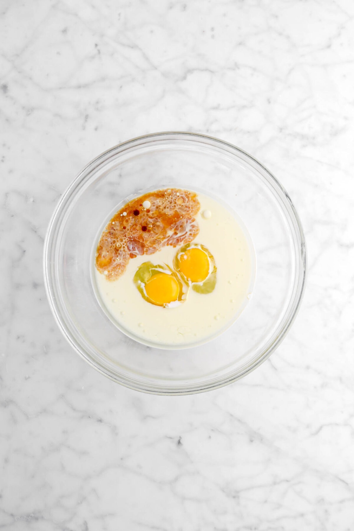 vanilla, vegetable oil, milk, and eggs in glass bowl