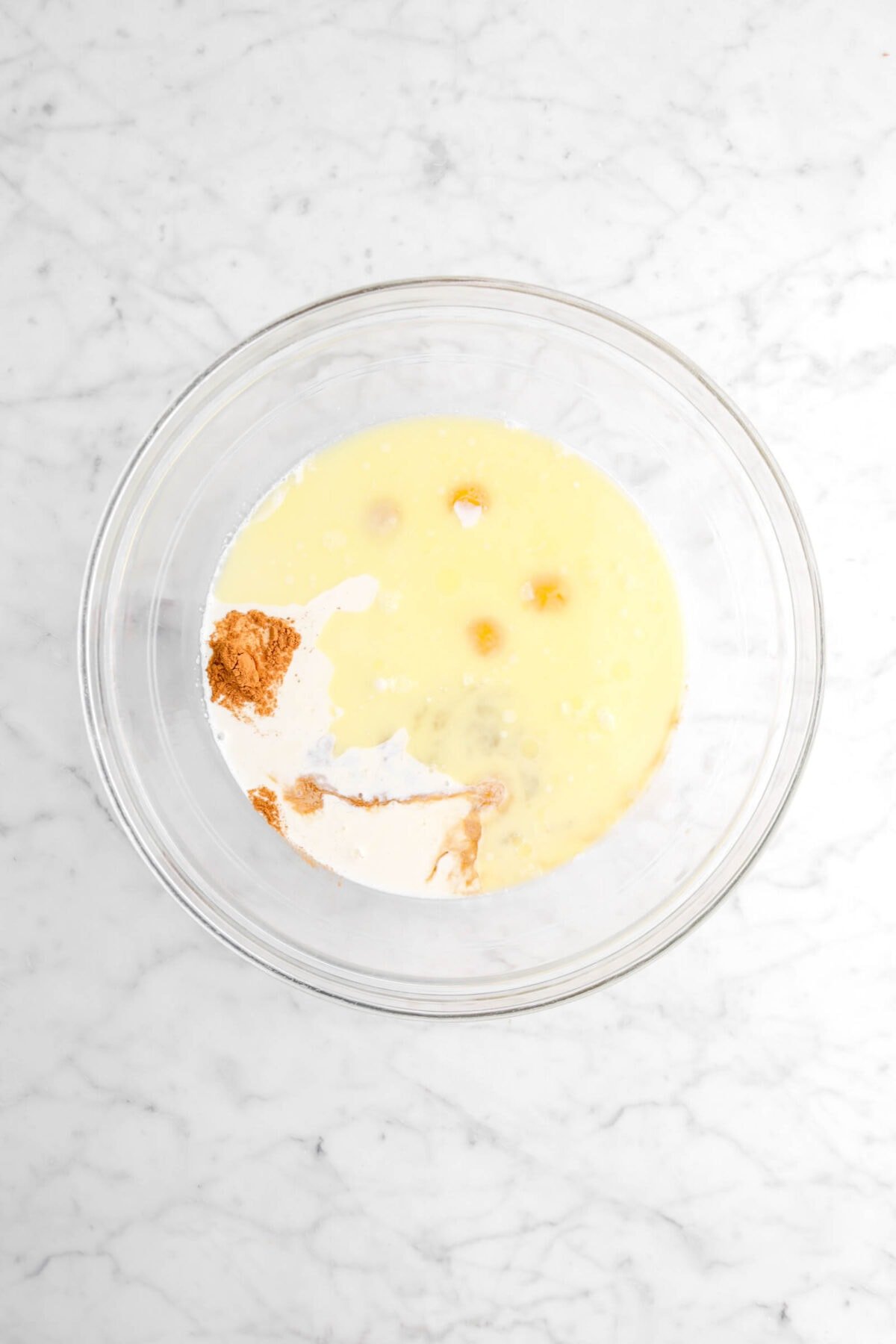 cinnamon, vanilla, milk, melted butter, and eggs in glass bowl
