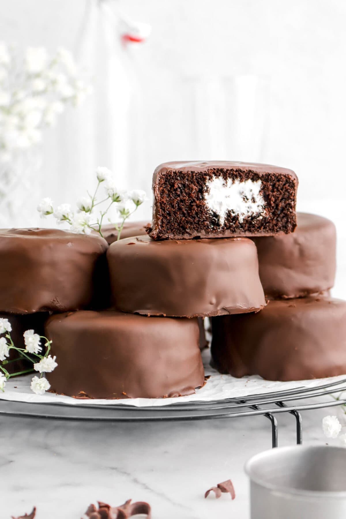 six stacked mini chocolate cakes with one cut in half on top