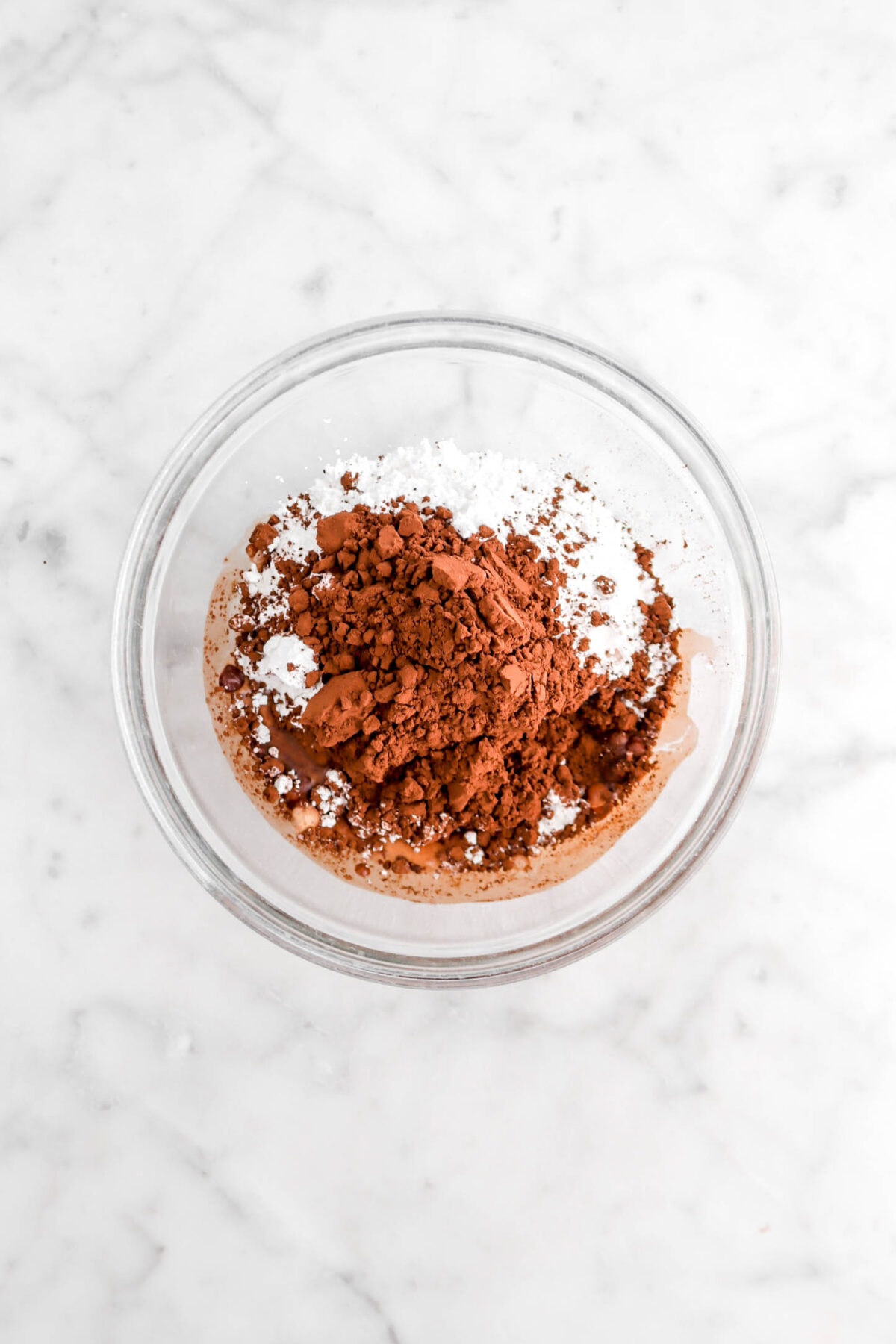 cocoa powder, milk, and powdered sugar in glass bowl