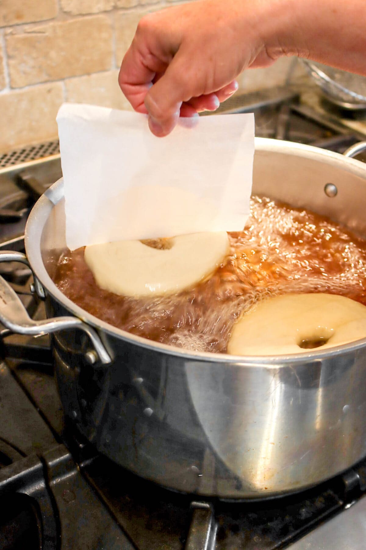 bagel being placed into stock pot
