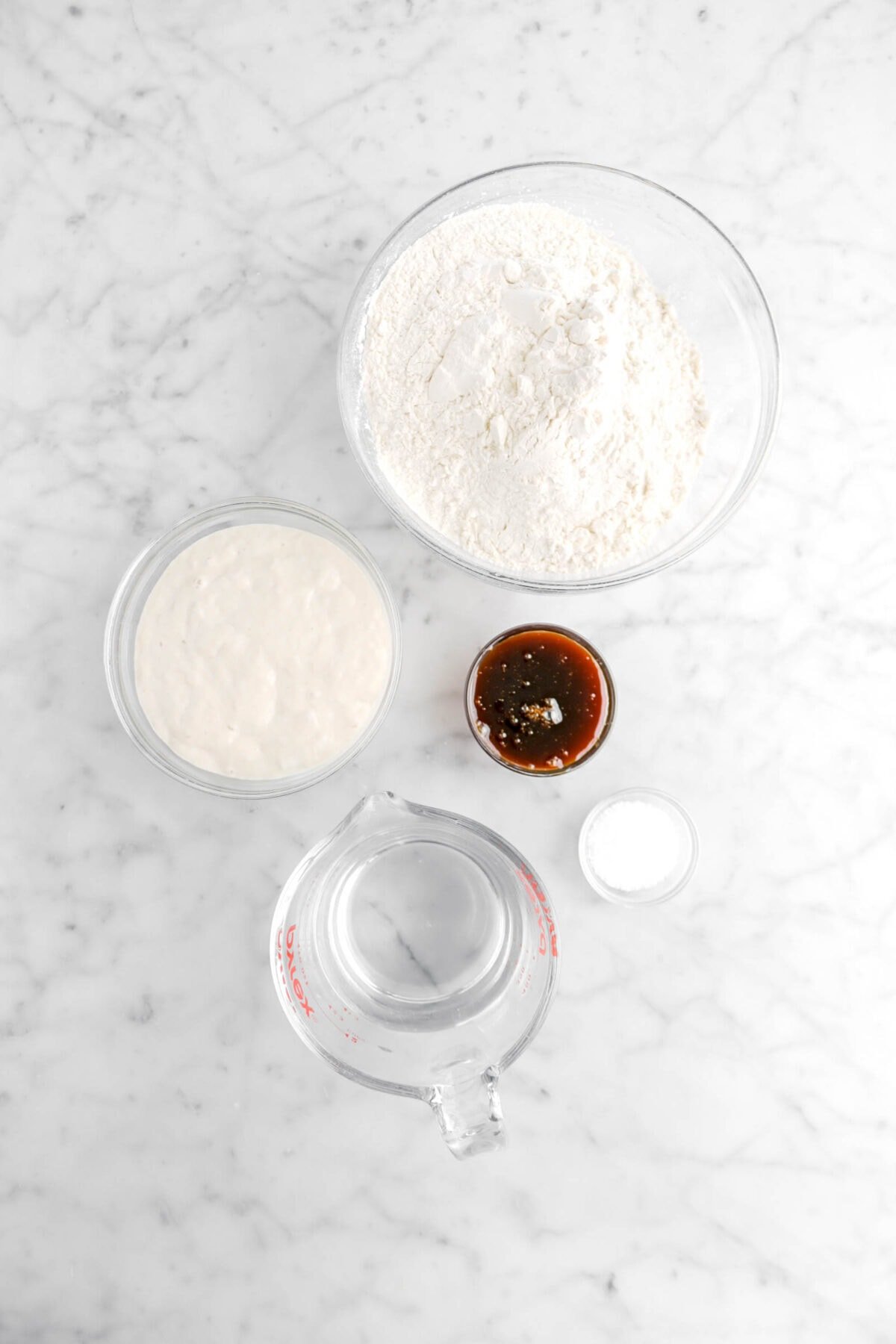 flour, sourdough starter, barley malt, salt, and water on marble counter