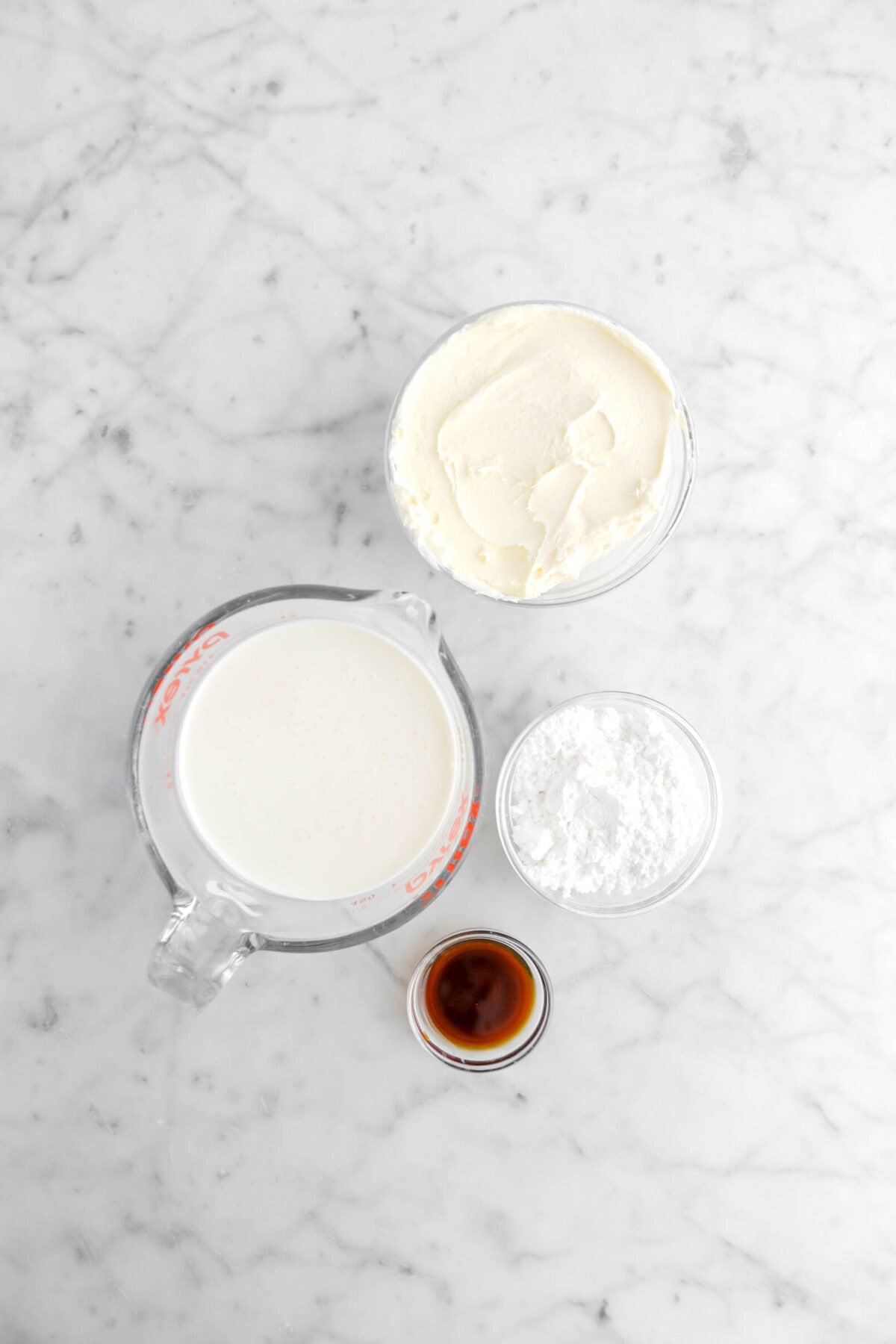 mascarpone, heavy cream, powdered sugar, and vanilla on marble surface