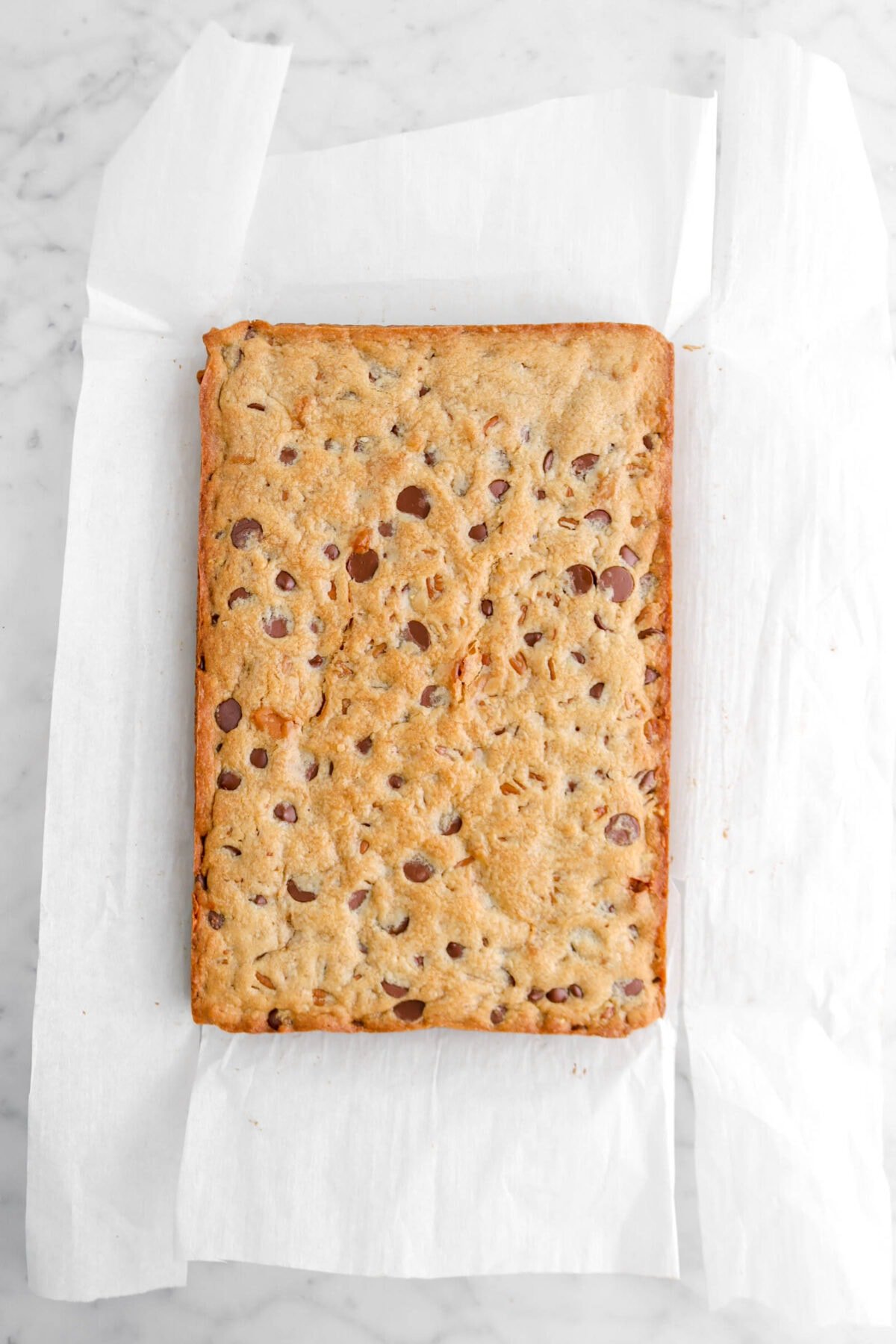 Rectangular cookie on parchment paper on marble surface