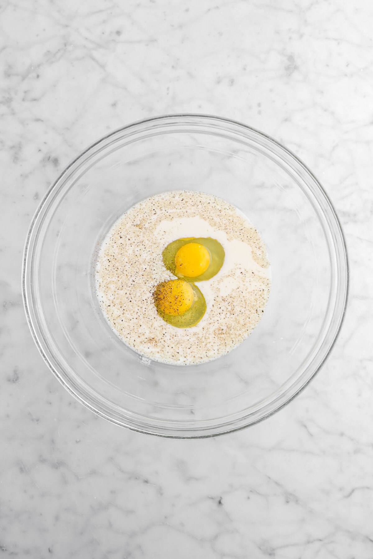 milk, pepper, and eggs in glass bowl