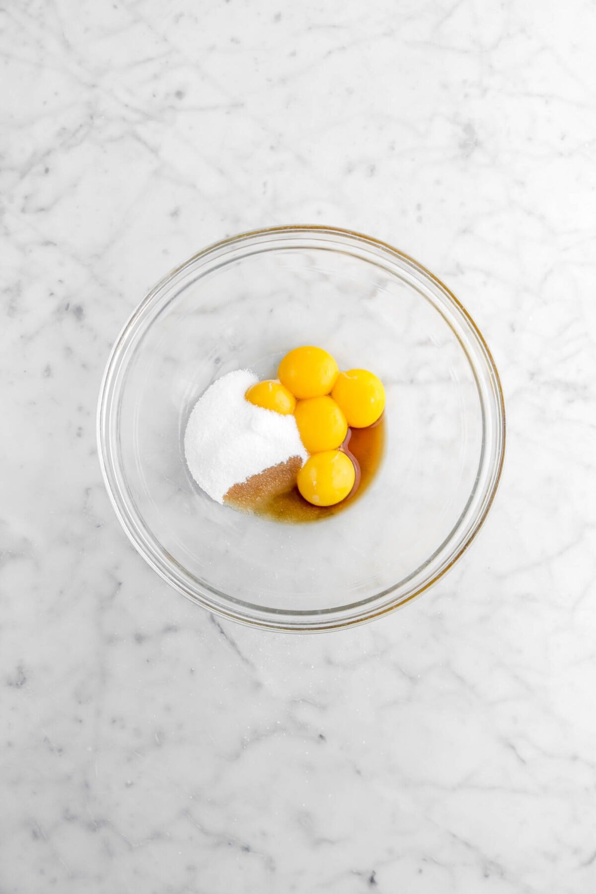 egg yolks, sugar, and vanilla in glass bowl