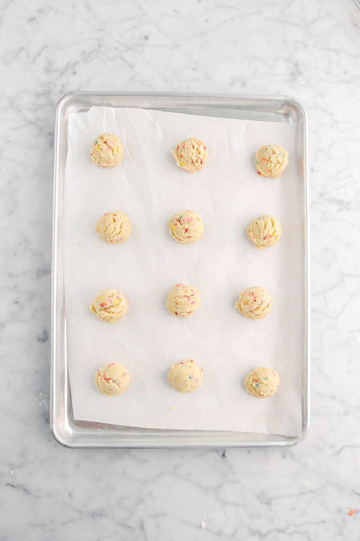 twelve cookie dough balls on parchment paper