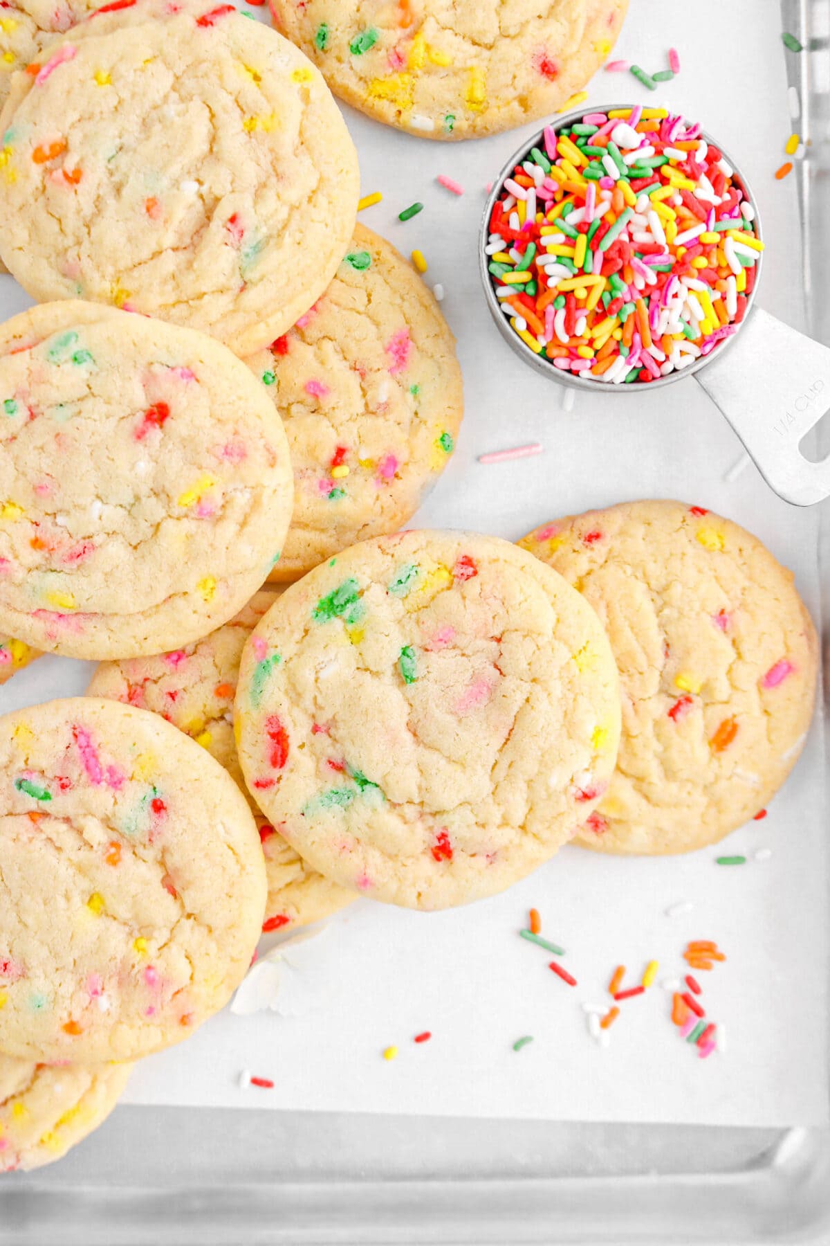 close up of eight funfetti cookies on sheet pan lined with parchment paper
