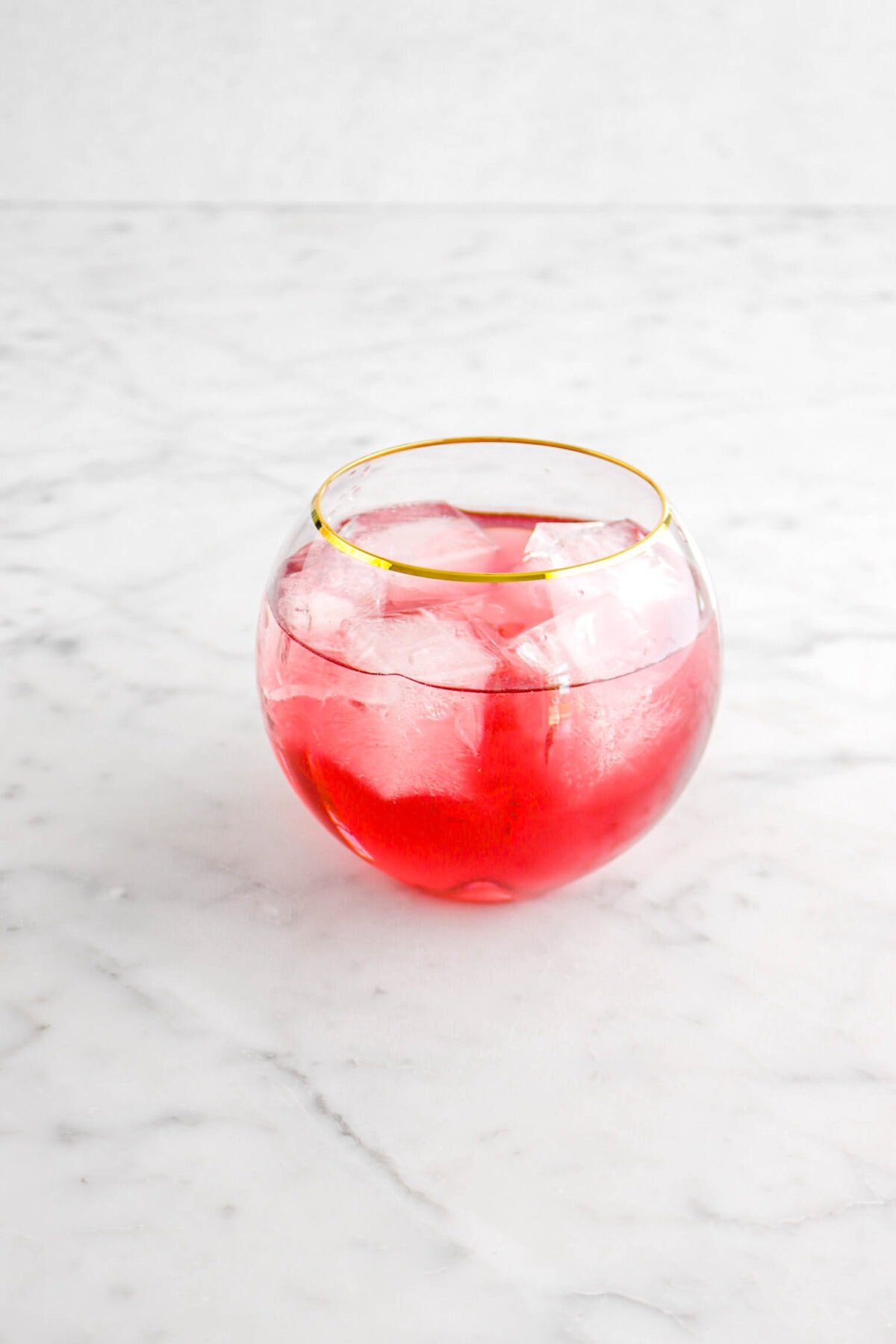 hibiscus cocktail with ice on marble surface