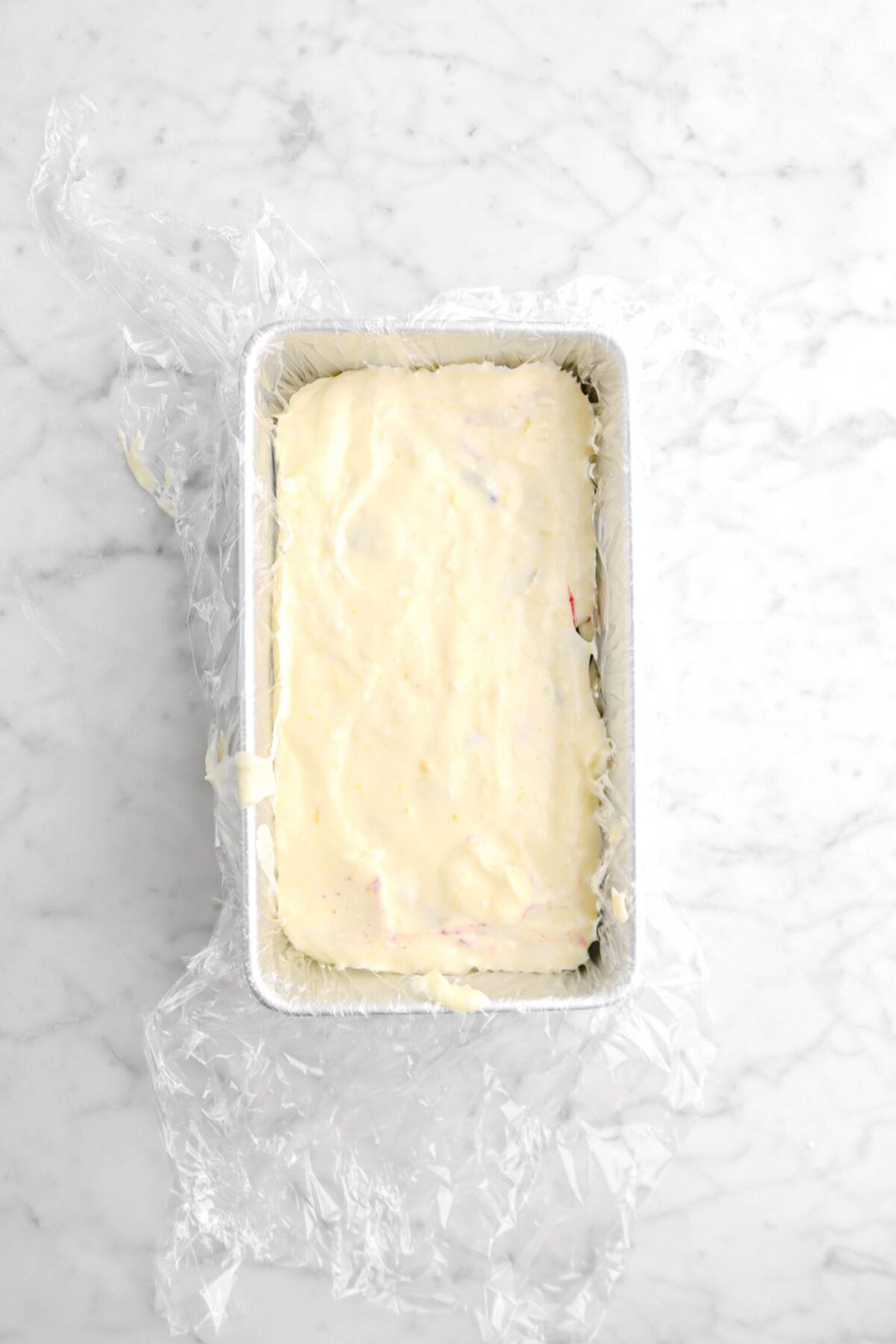 lemon mousse covering jam layer in loaf pan