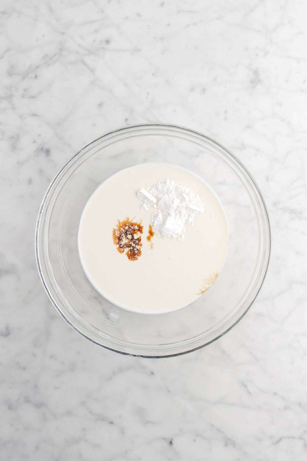 heavy cream, vanilla, and powdered sugar in large glass bowl
