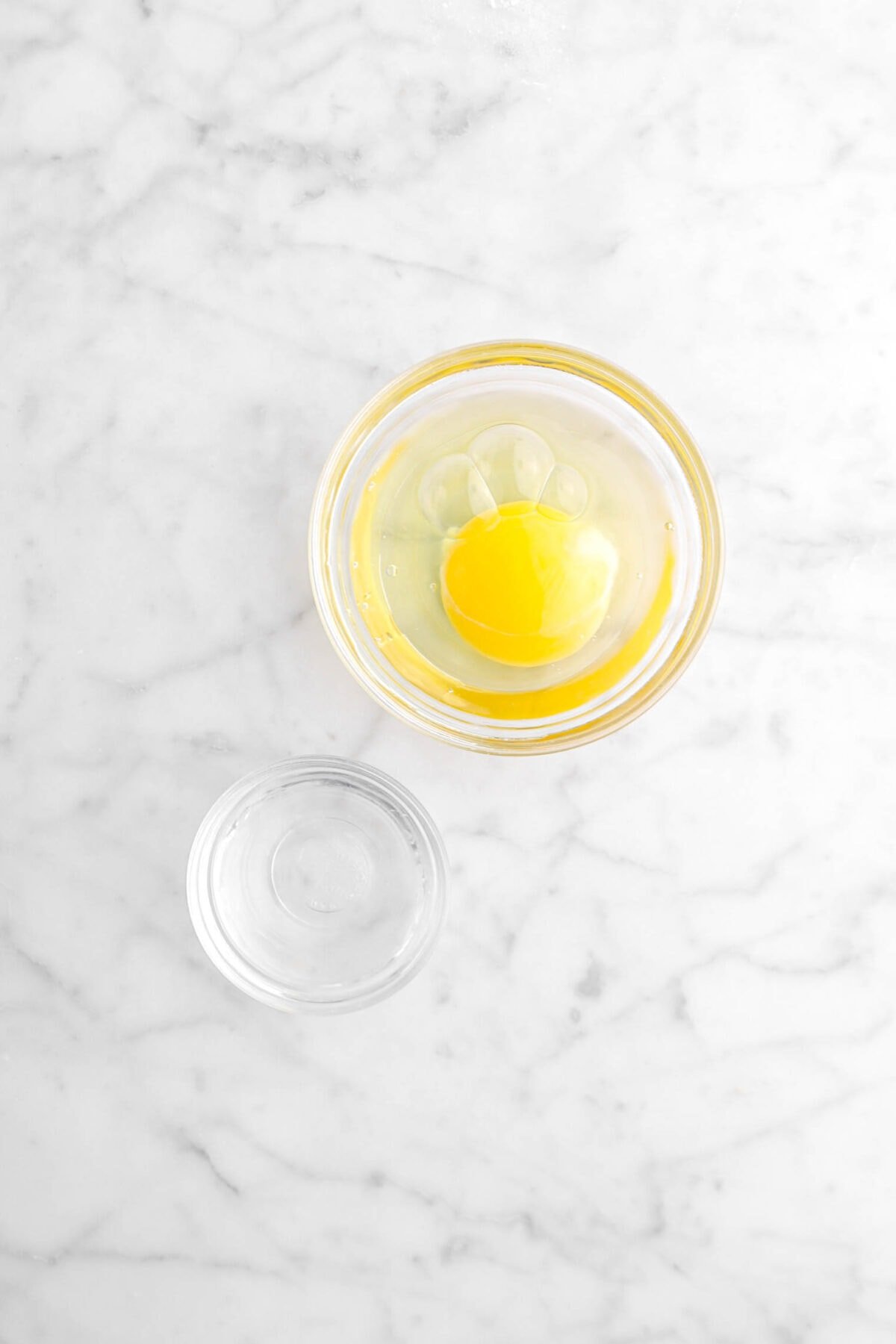egg and water in two bowls on marble surface