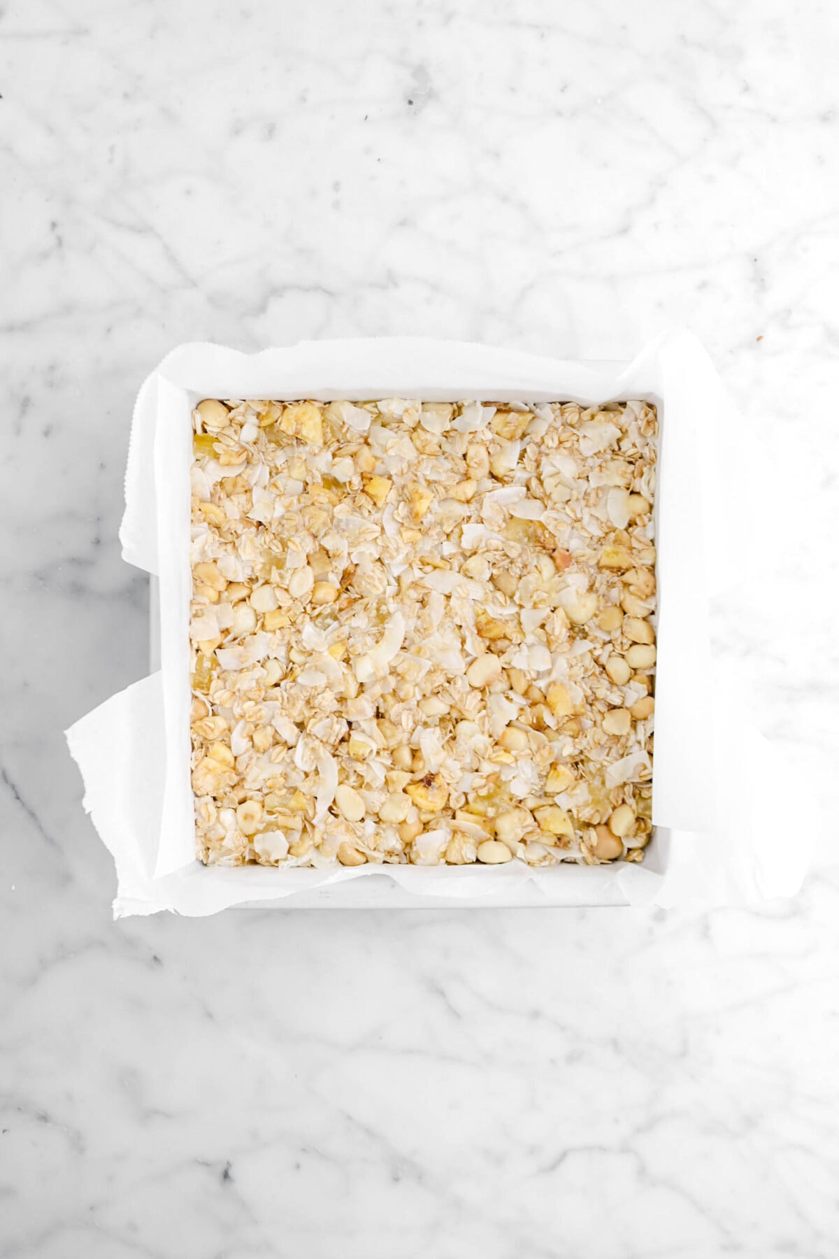 granola mixture packed into lined square pan