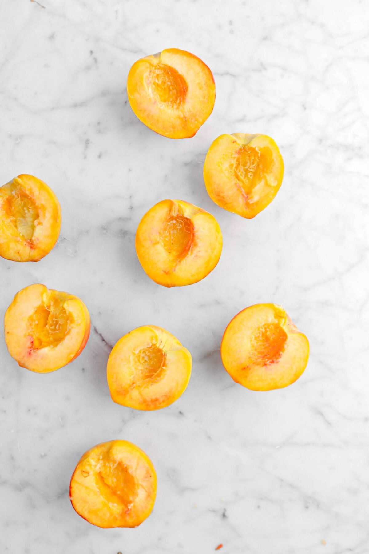 halved peaches on marble surface