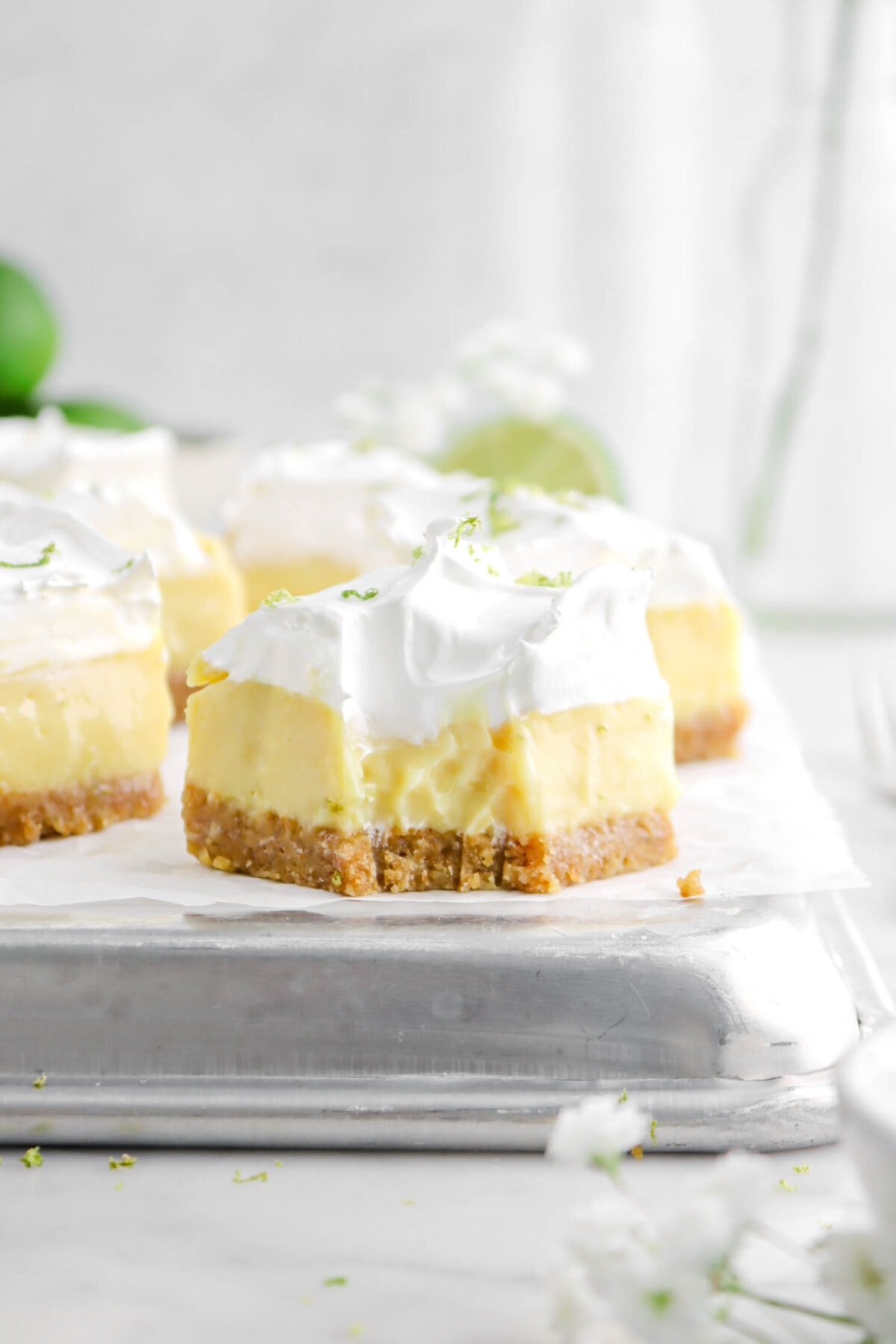close up of key lime pie bar with bite missing and more bars behind