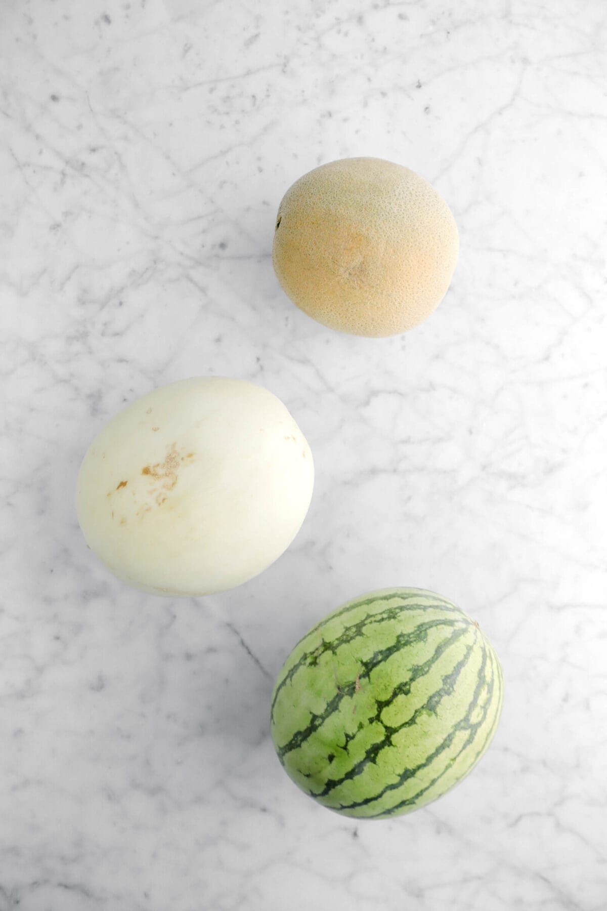 cantelope, honeydew, and watermelon on marble surface
