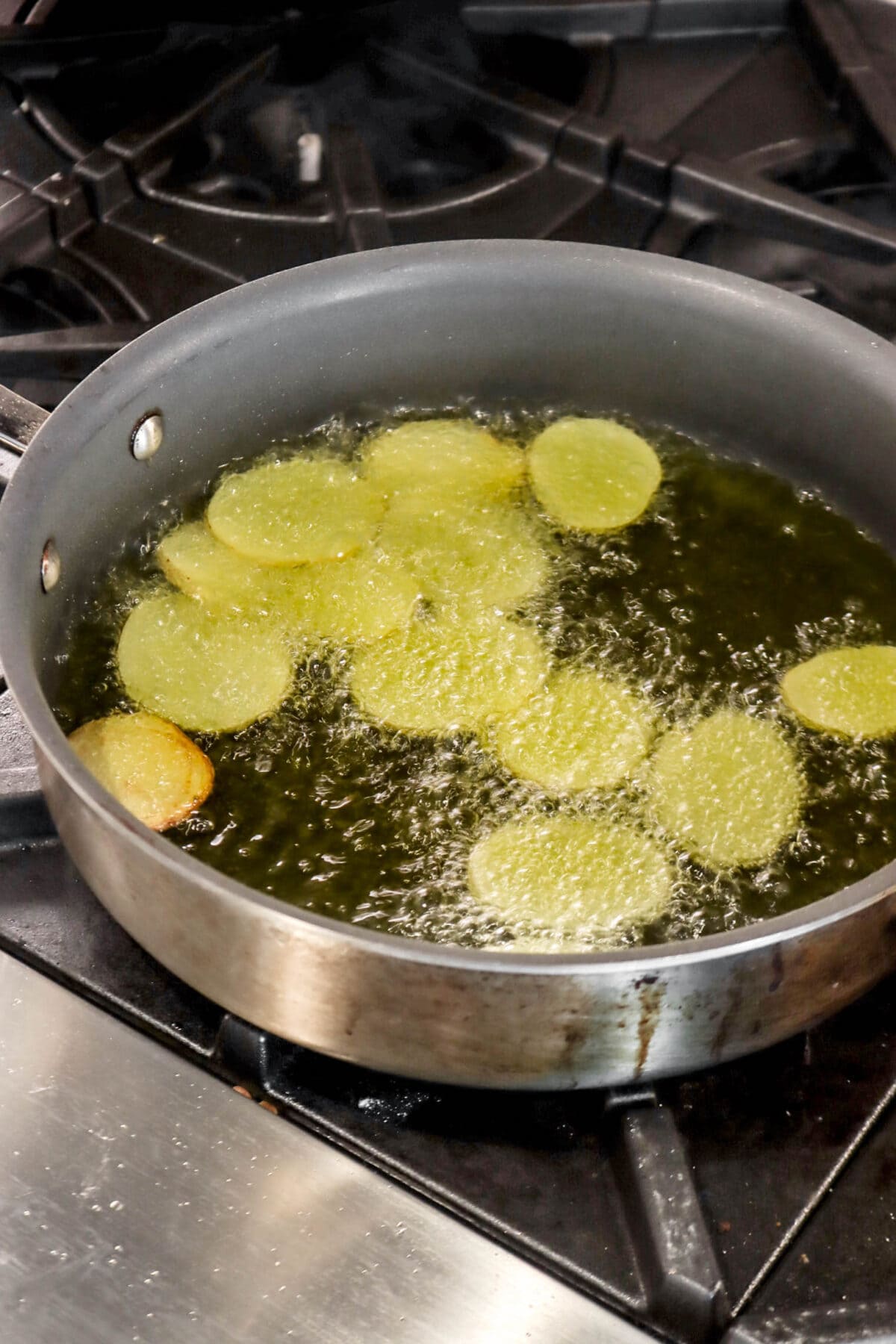 potato slices being fried in small pot