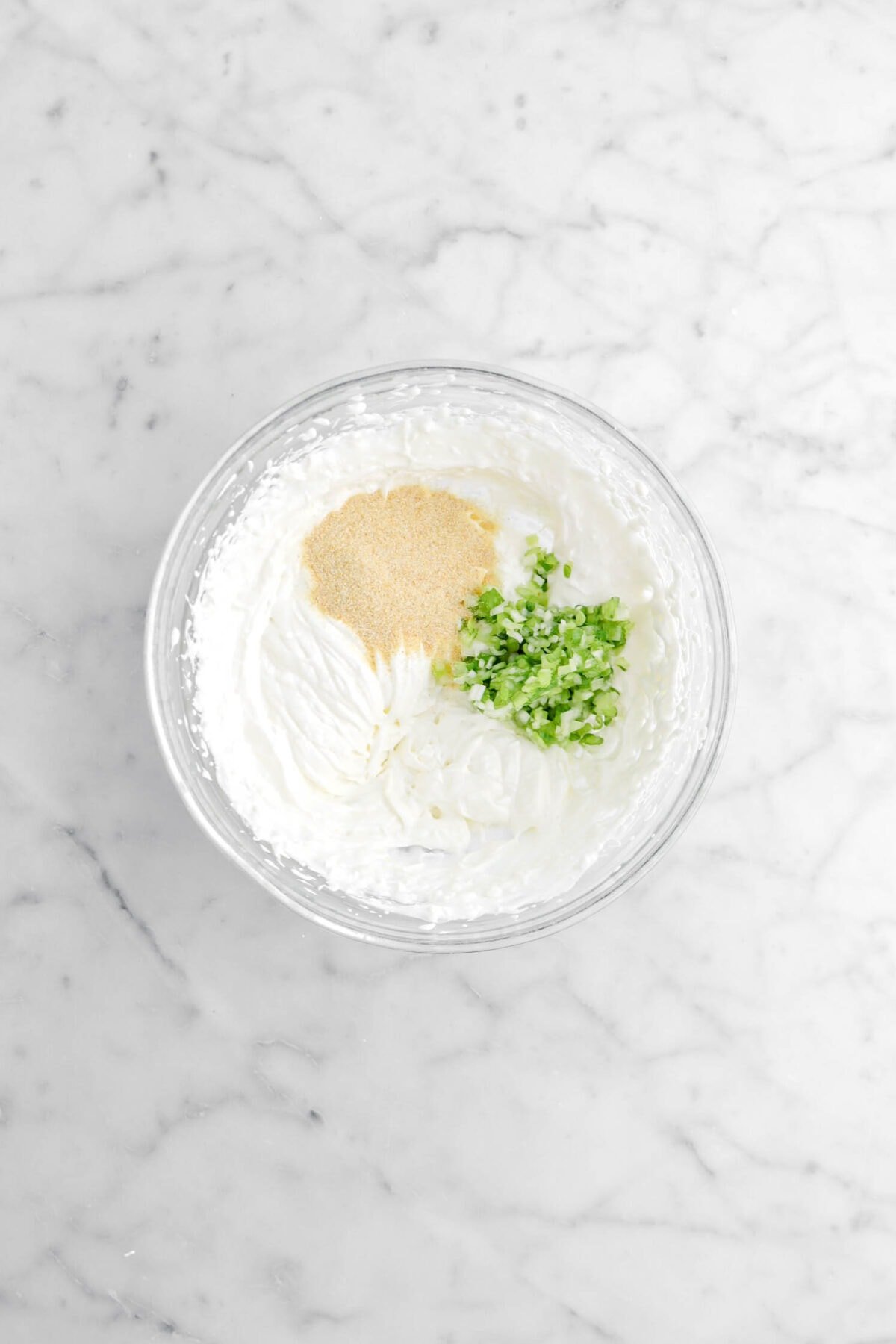 garlic powder, green onions, and whipped sour cream in glass bowl