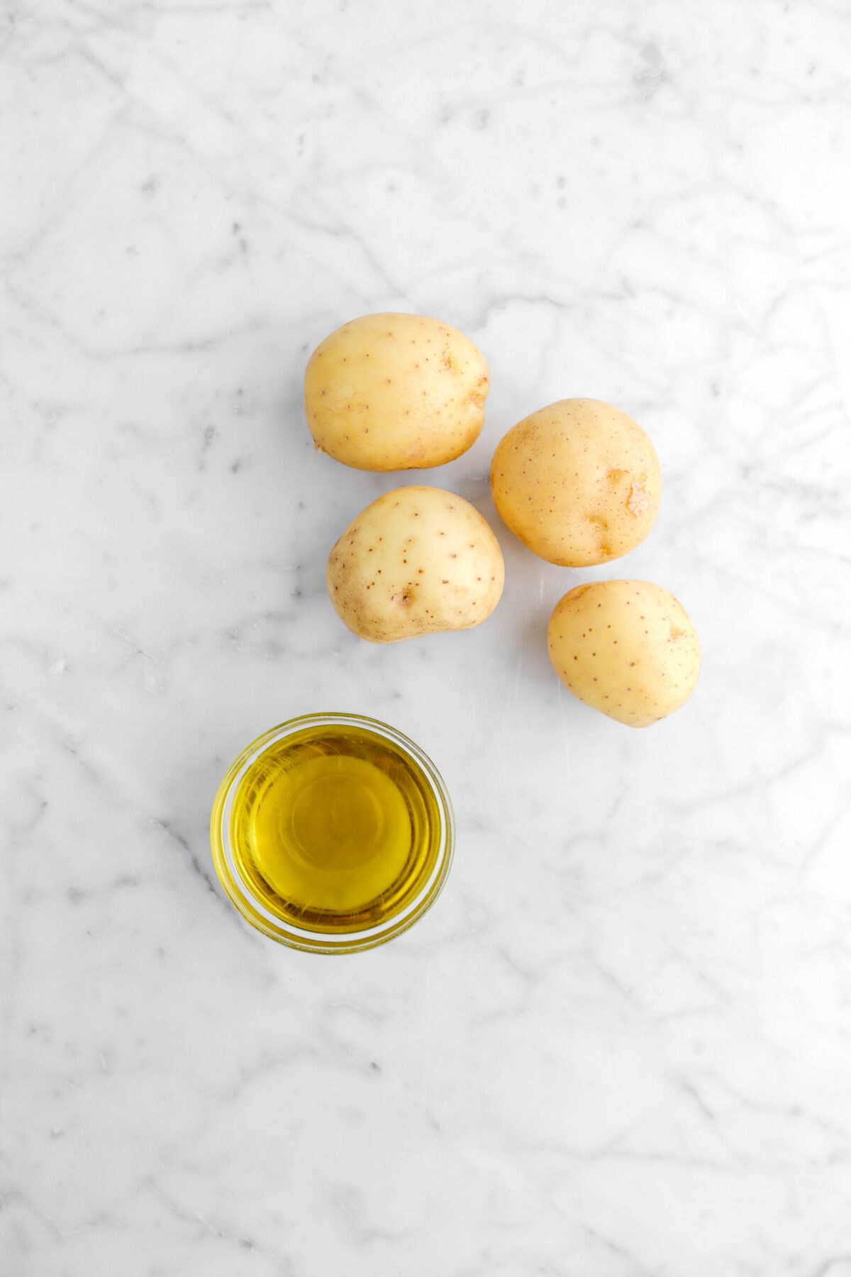 potatoes and olive oil on marble surface