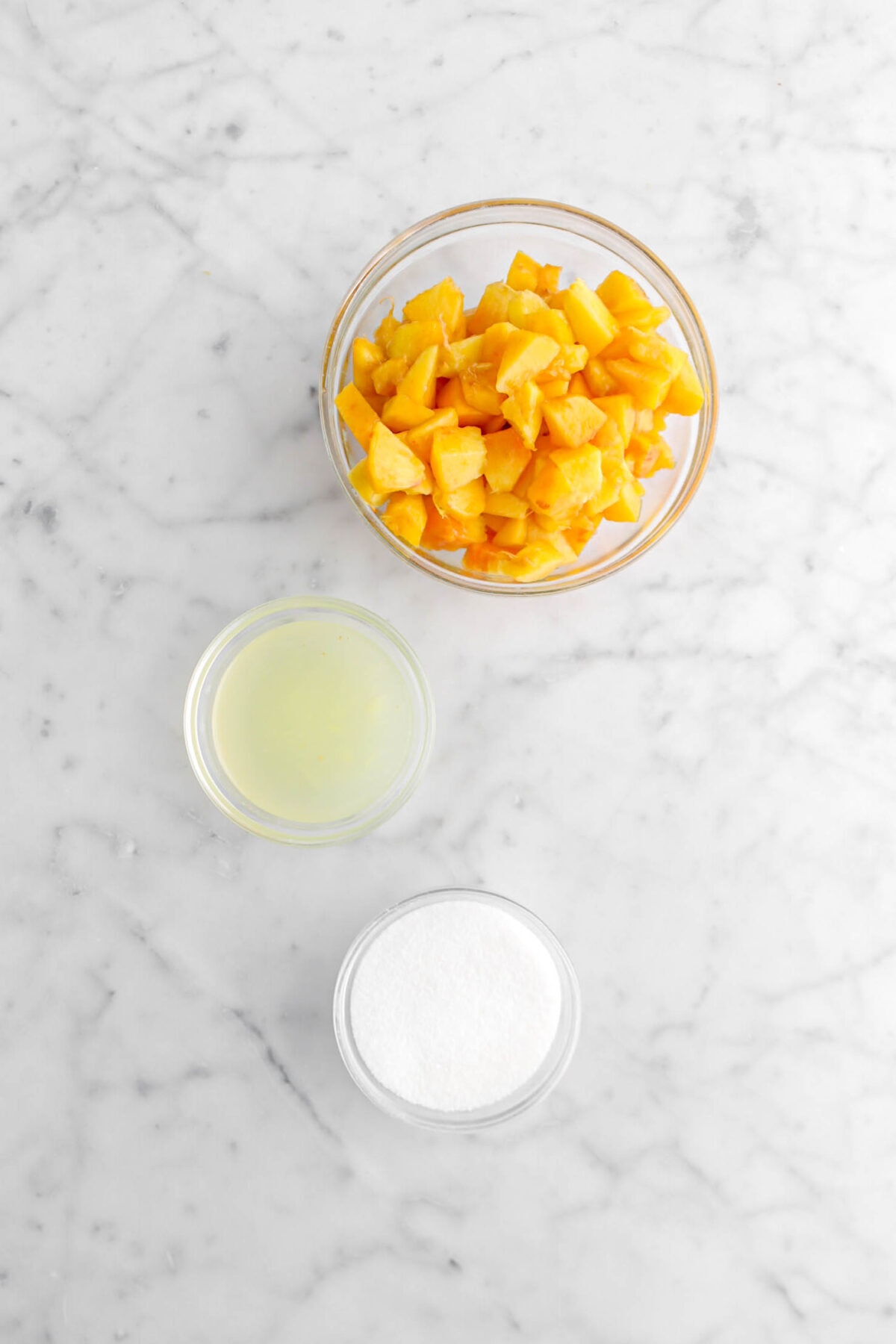 chopped peaches, lemon juice, and sugar on marble surface