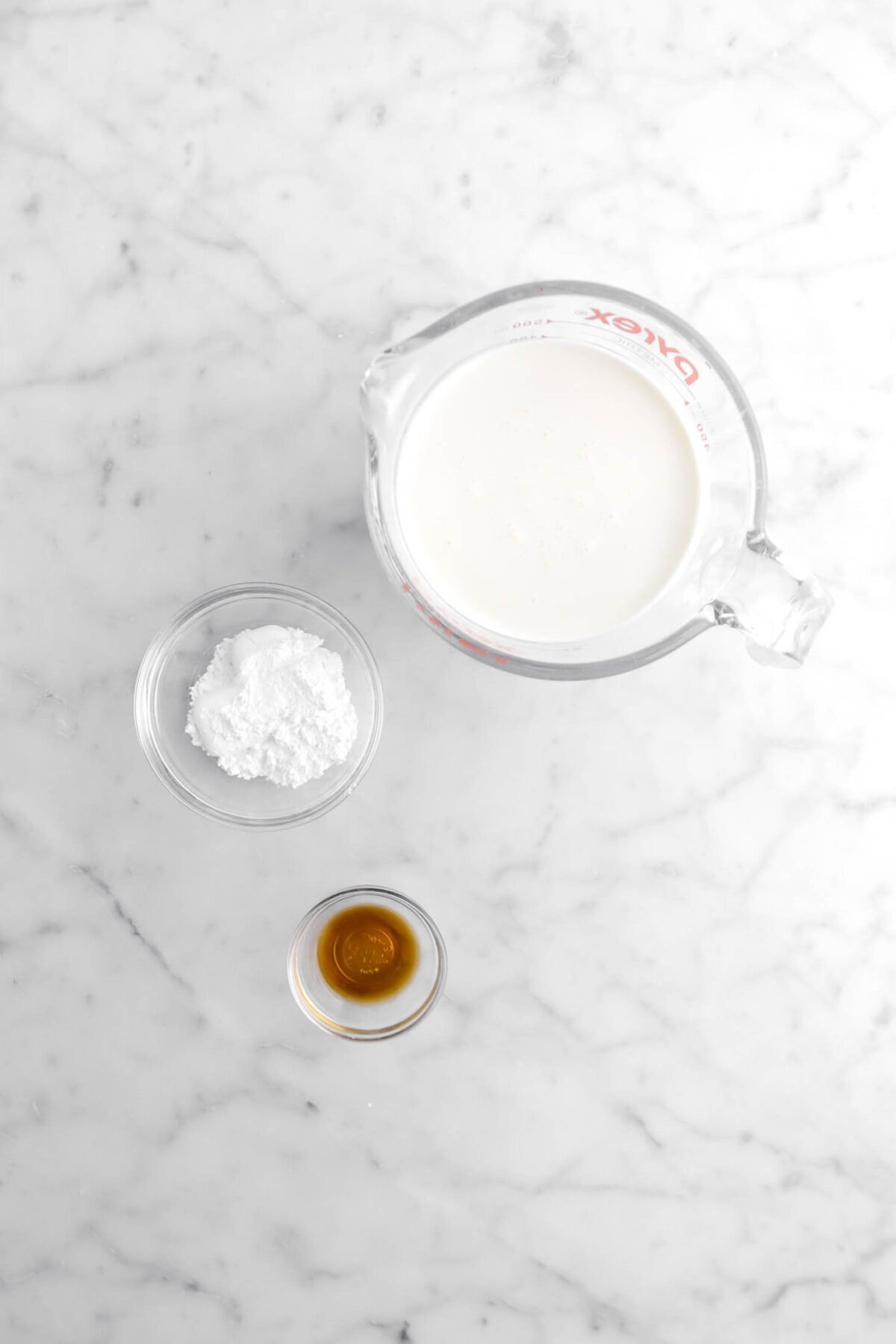 heavy cream, powdered sugar, and vanilla on marble surface
