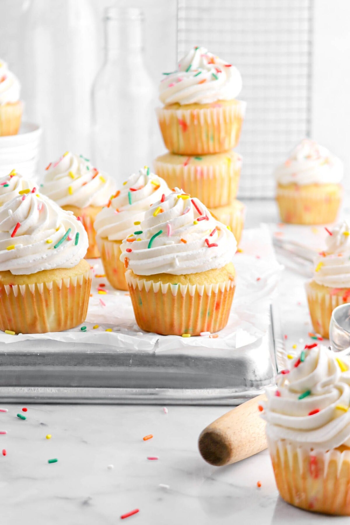 funfetti cupcakes on upside down sheet pan with stack of cupcakes behind