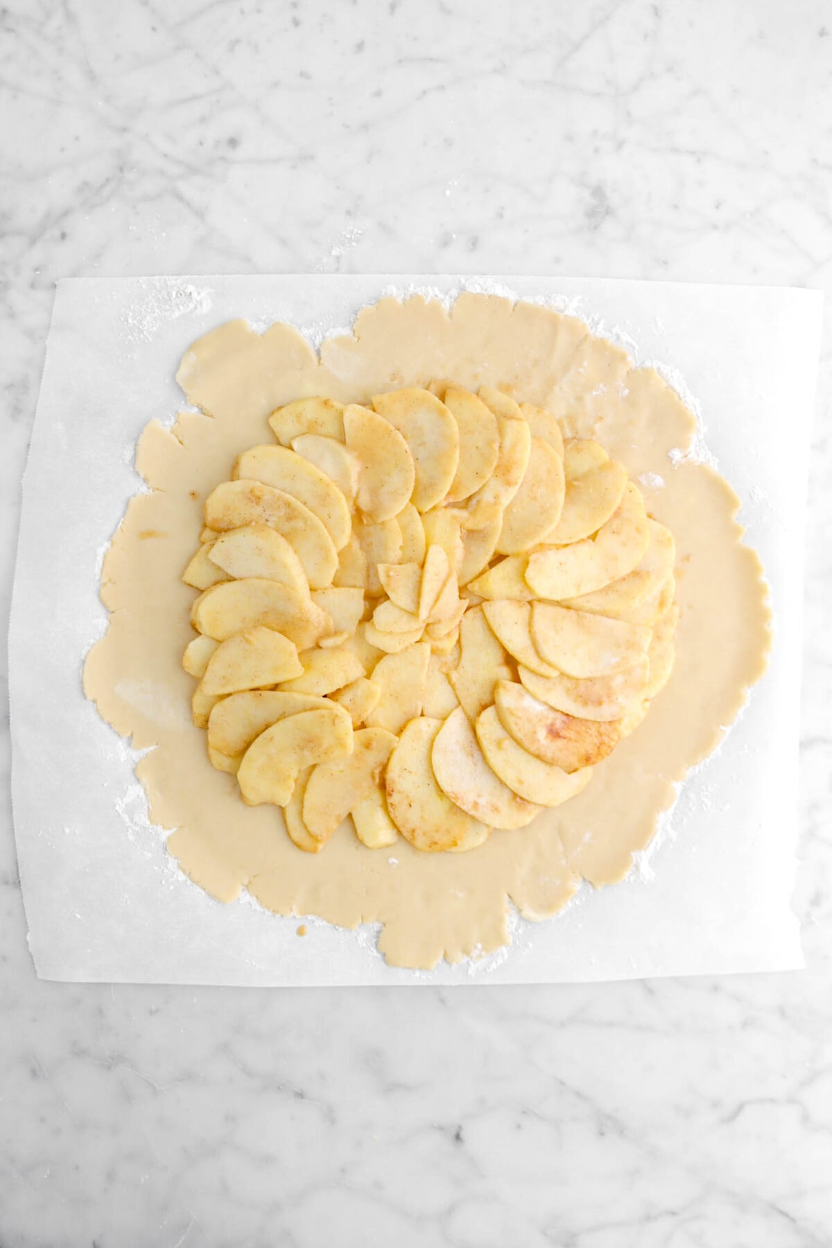 apple slices laid in a circle on rolled out crust