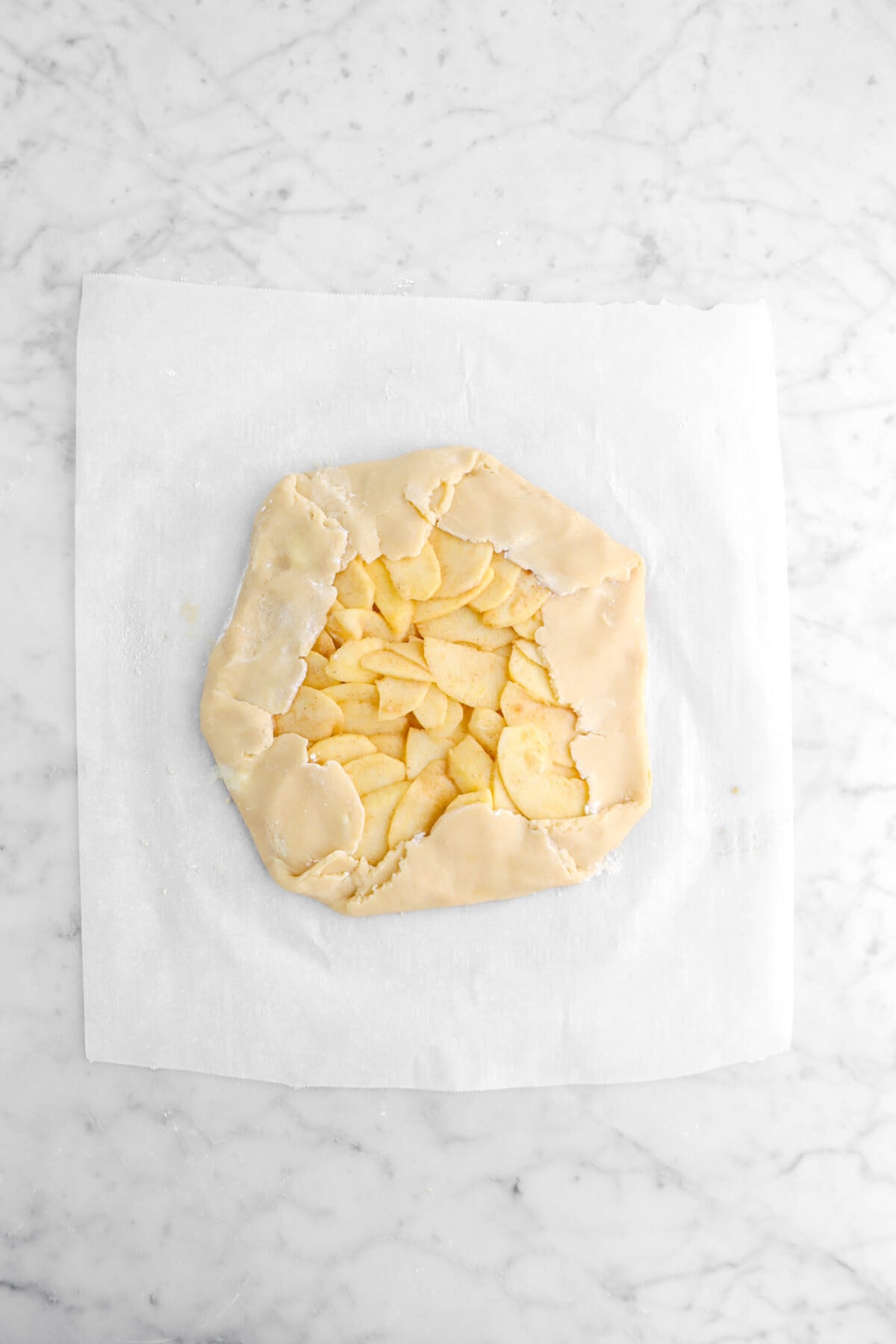 unbaked apple galette on parchment paper