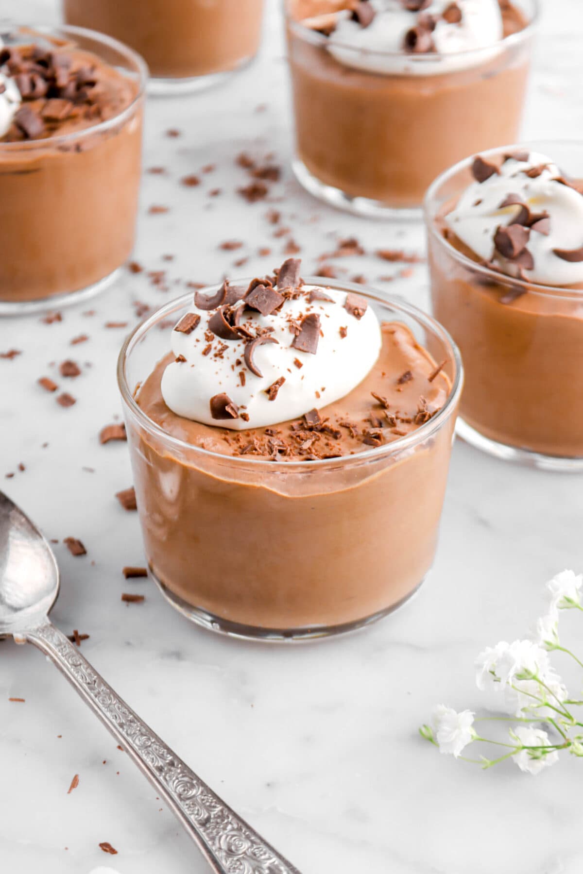 front shot of chocolate mousse in small glass with whipped cream and chocolate curls on top