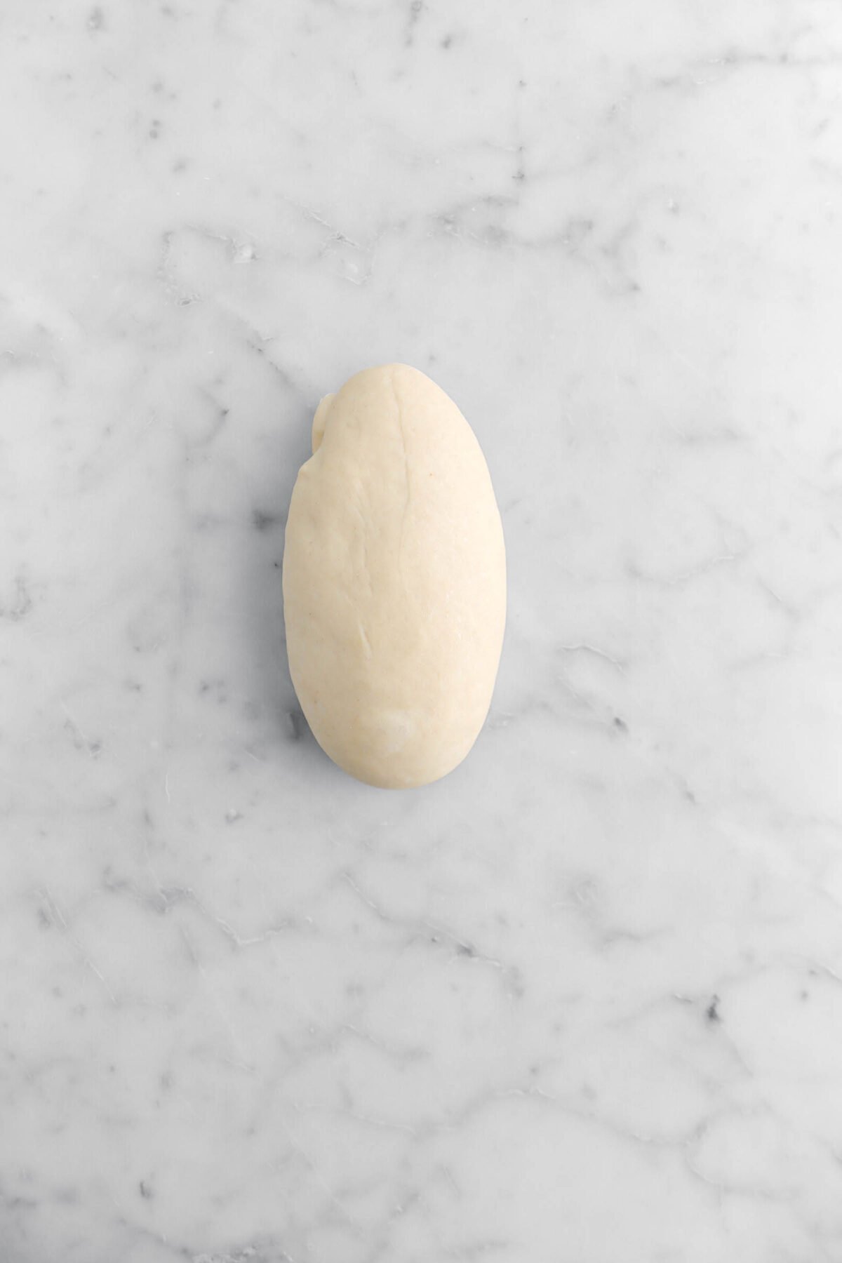 oval shaped dough on marble surface.