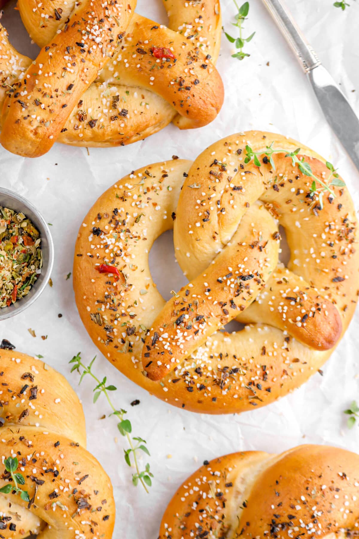 cropped close up of pretzel with thyme sprig on top.