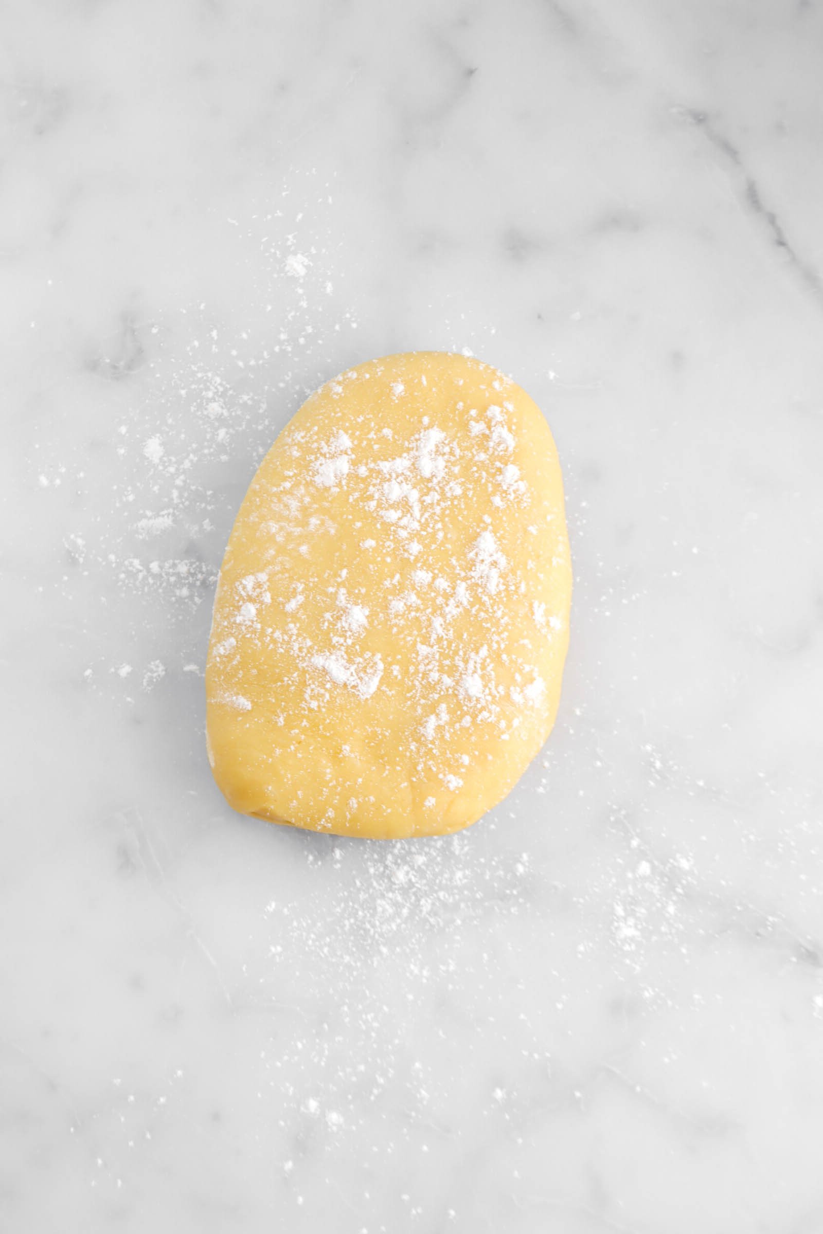 lightly floured dough on marble surface.