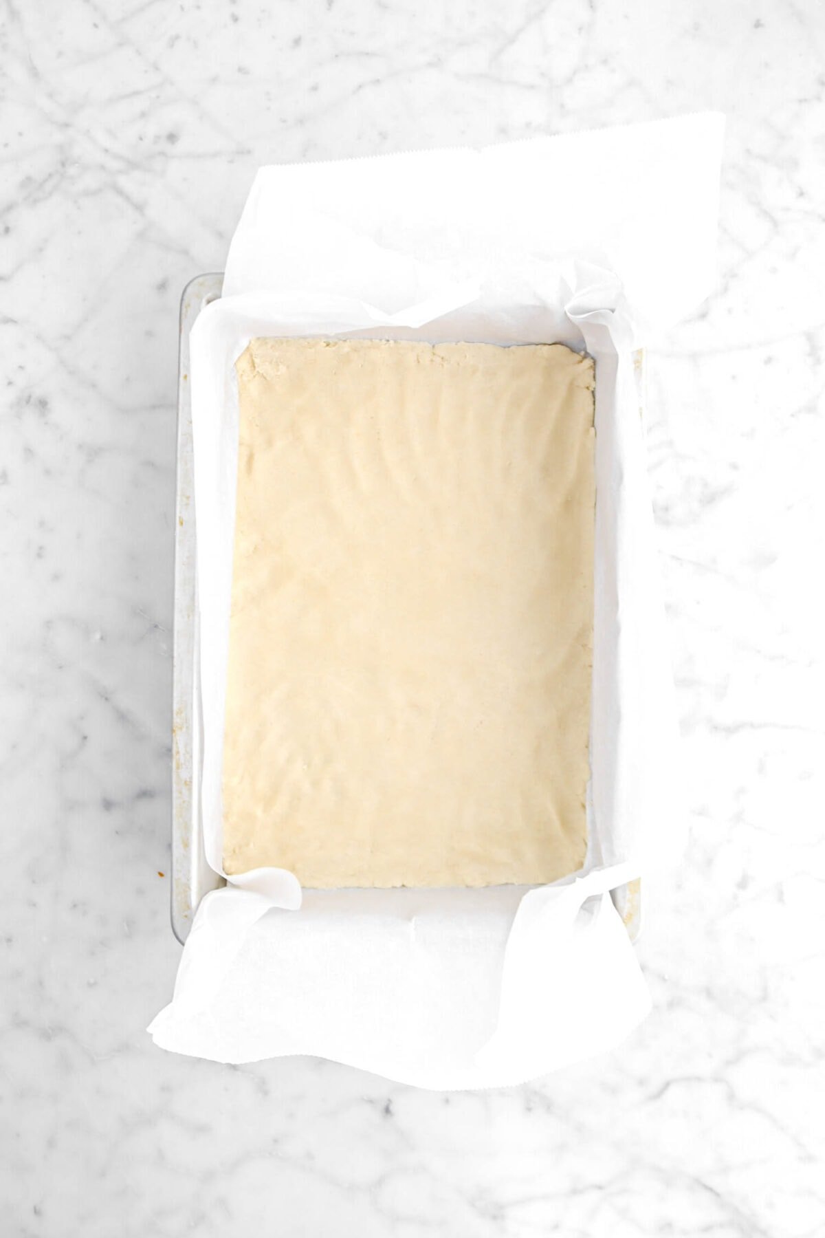 flattened shortbread dough in lined pan