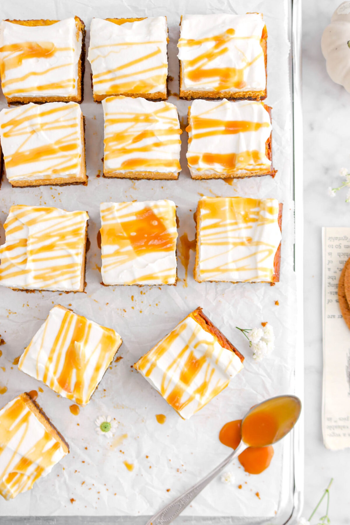 overhead shot of twelve bars with caramel sauce drizzled on top and spoon of caramel beside.