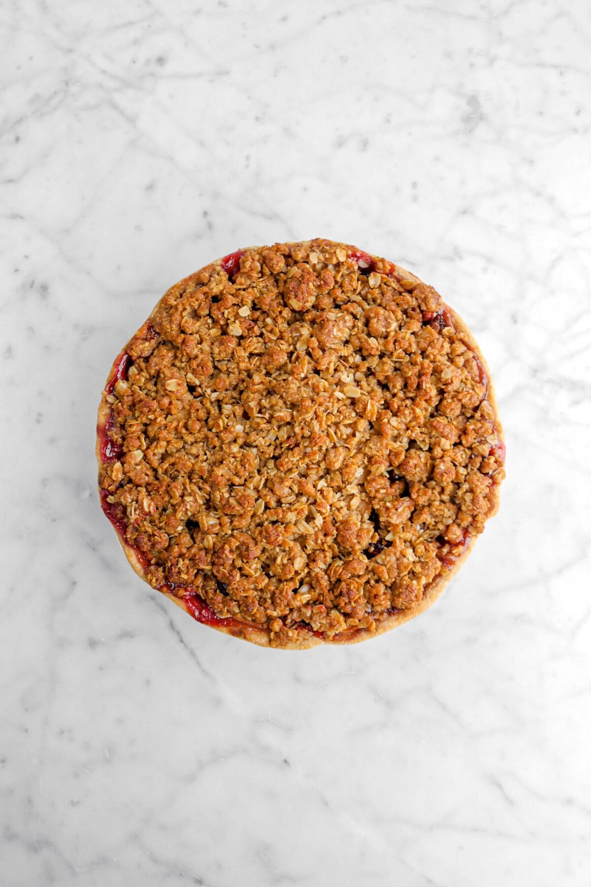 baked crumble pie on marble surface.