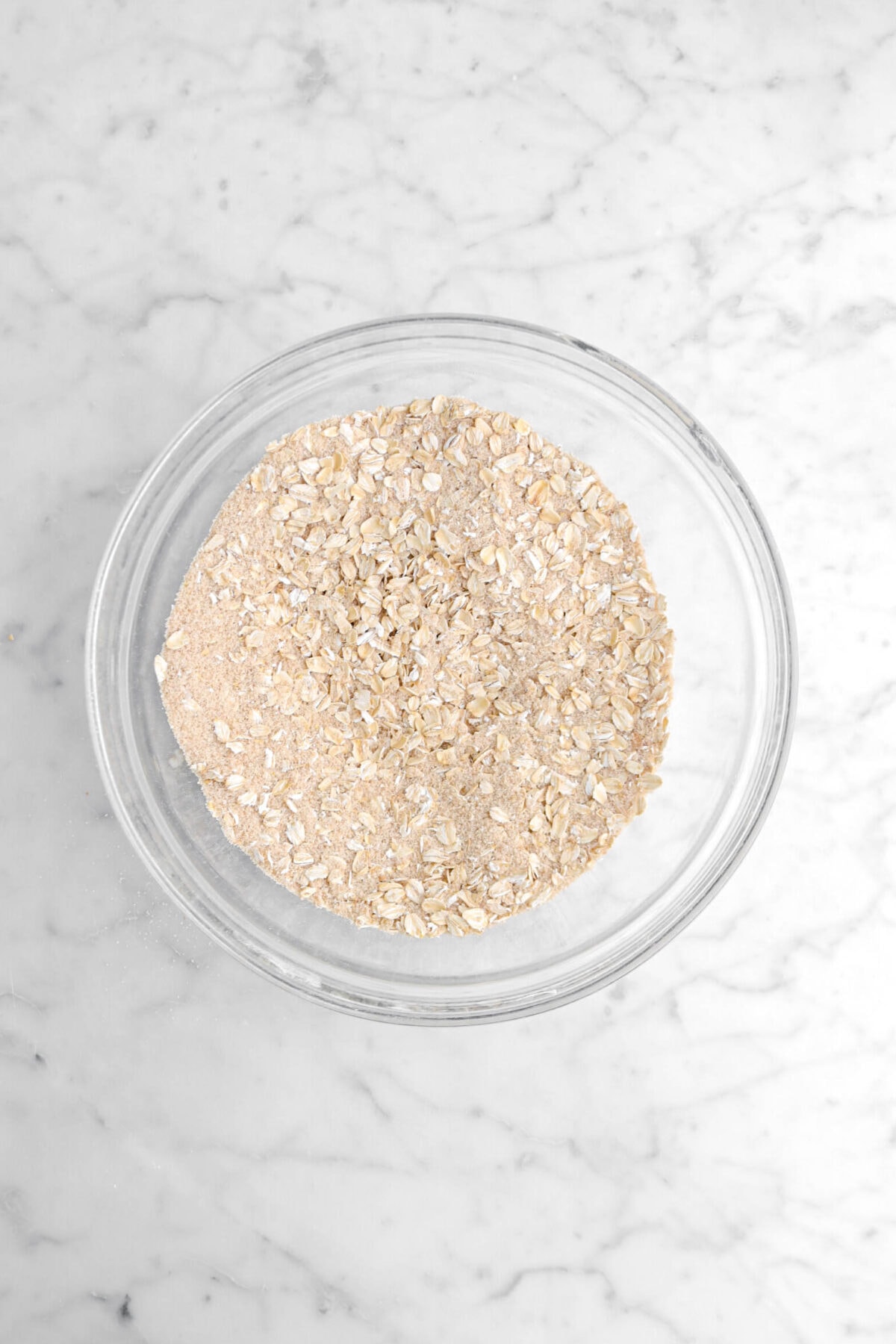 oats and sugar mixture whisked in glass bowl.