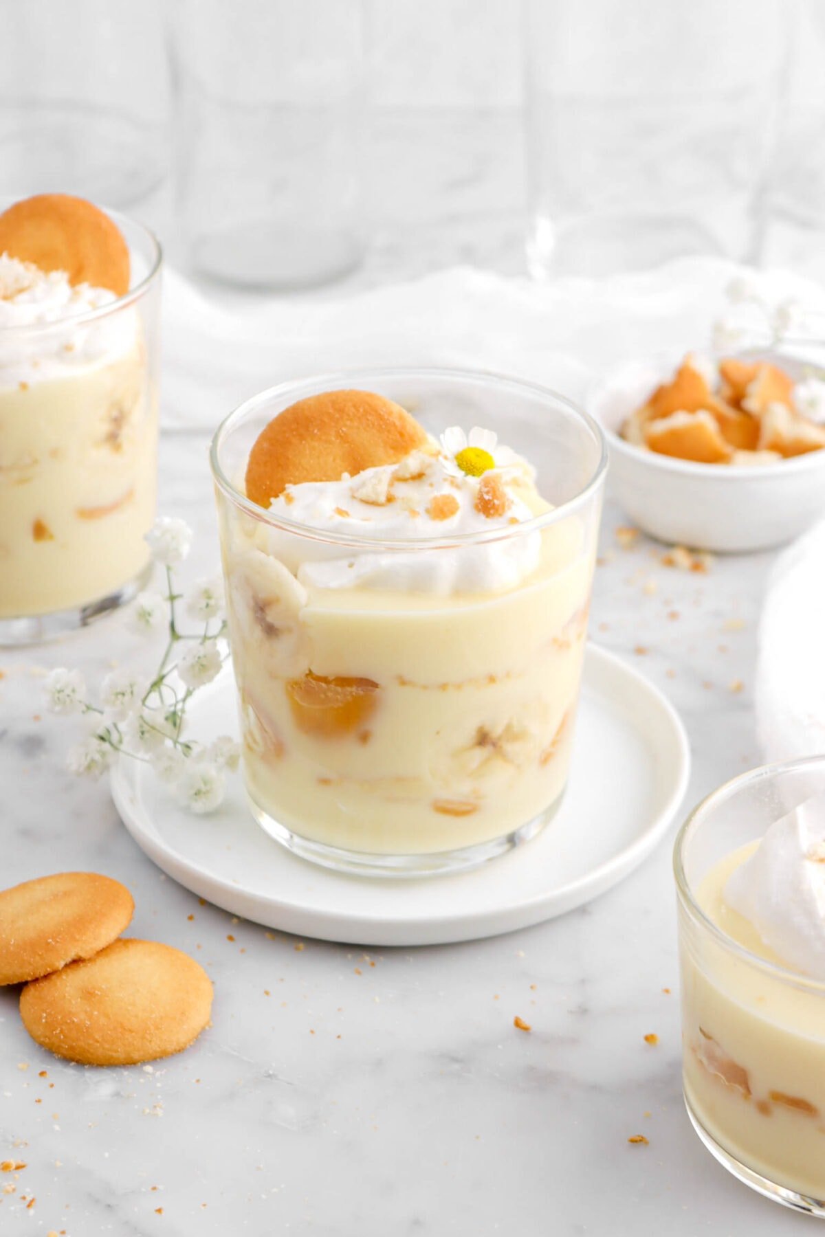 angled close up of banana pudding in glass on a white plate.