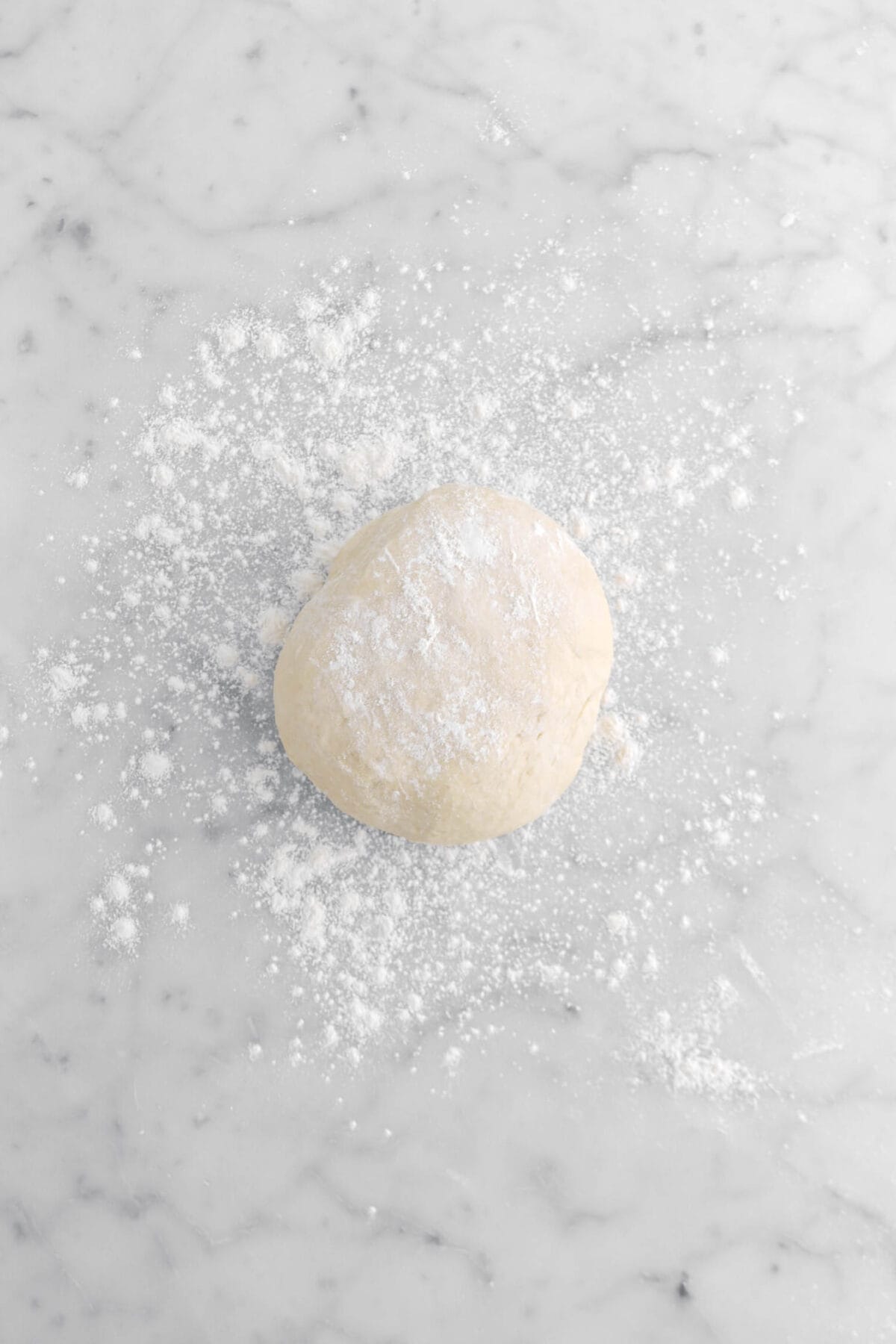 dough ball on lightly floured marble surface.