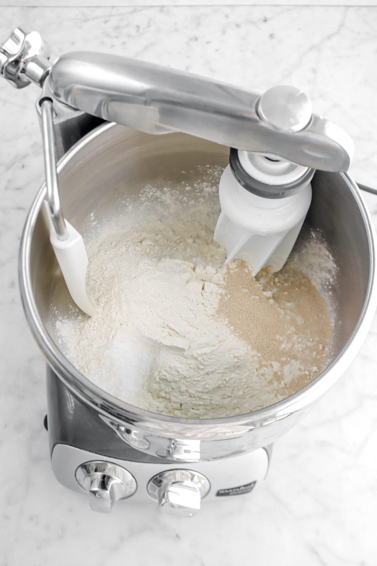 flour, salt, and yeast on marble surface in stand mixer.