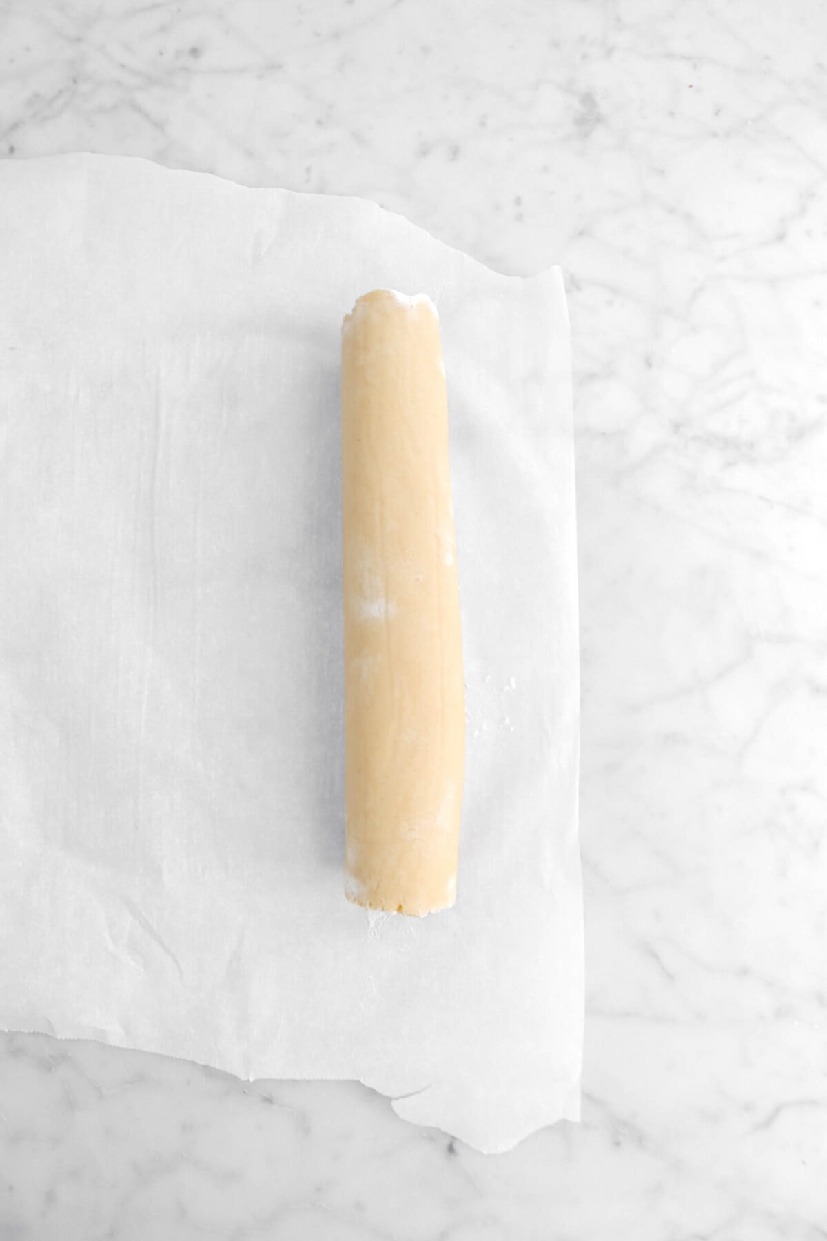 dough rolled into a log on parchment paper.